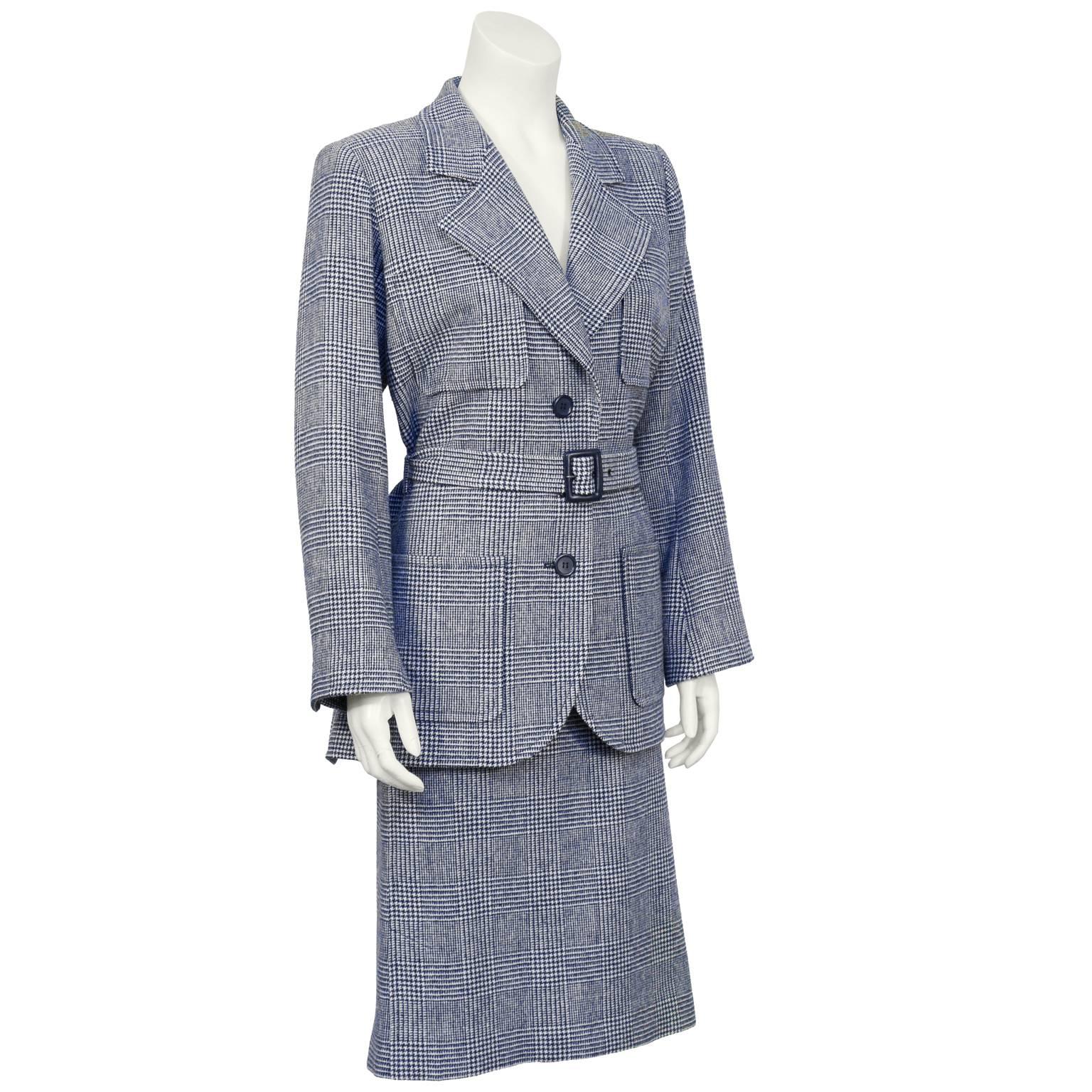 Blue and cream wool checked houndstooth Yves Saint Laurent suit from the 1970's. The Safari style jacket has a notched lapel, four front patch pockets and a belt at the natural waist. The skirt has a banded waist, side slits and zips up the side. In
