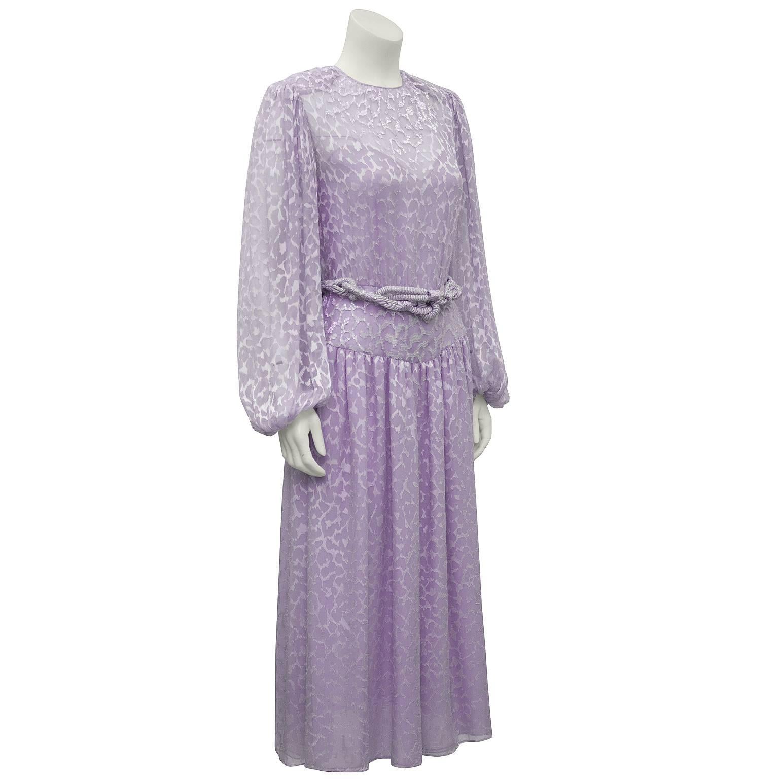 Lavender silk chiffon beaded evening dress by Oscar de la Renta. Fabric has an all over devoree leopard print with white iridescent beading at the neckline and along the waistband. Full sleeves with elasticized cuffs. Attached lavender slip and