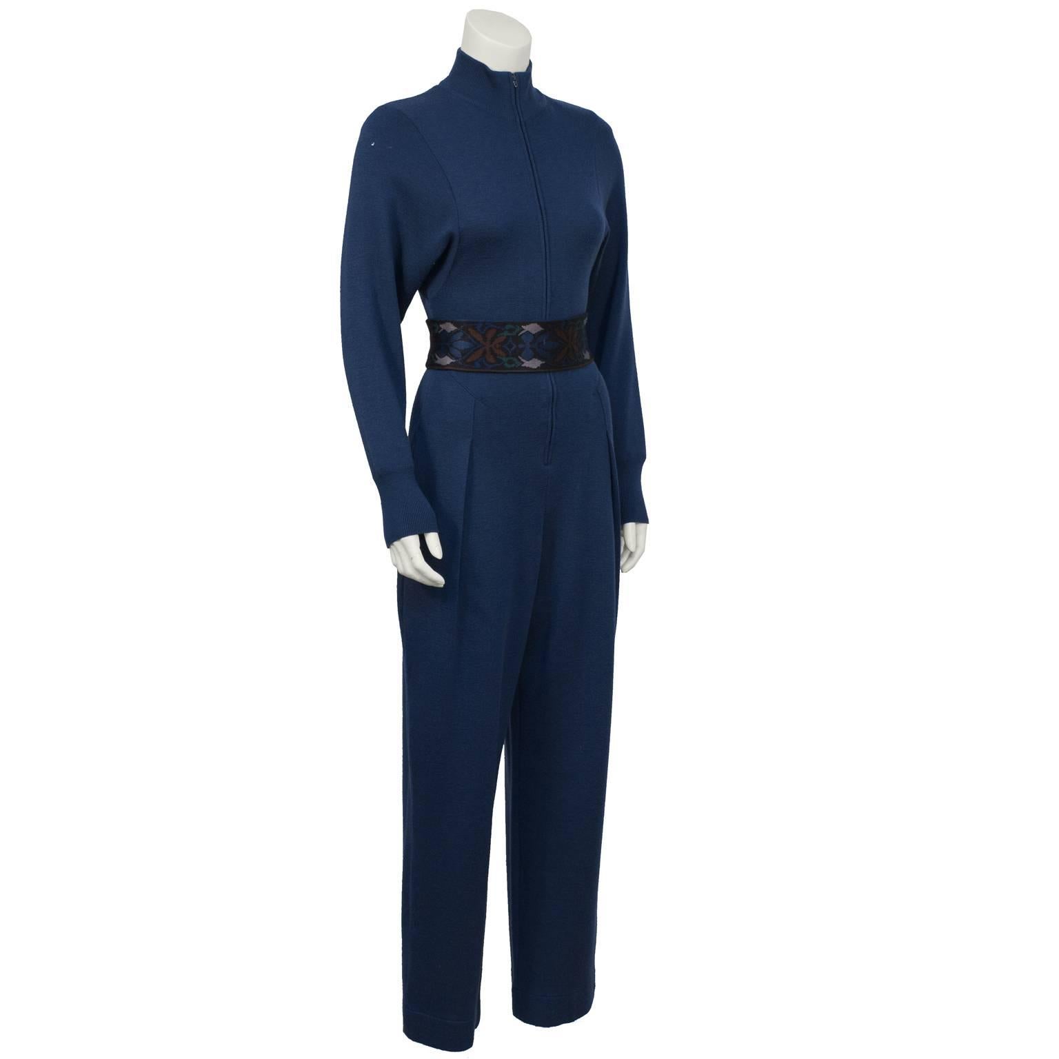 Cozy teal wool knit jumpsuit by Claude Montana from the 1980's. The jumpsuit zips up the front with a ribbed high collar, ribbed cuffs and a wide leg. Inseam pockets on the hips. Fitted at the waist, stretch belt is reversible with two different