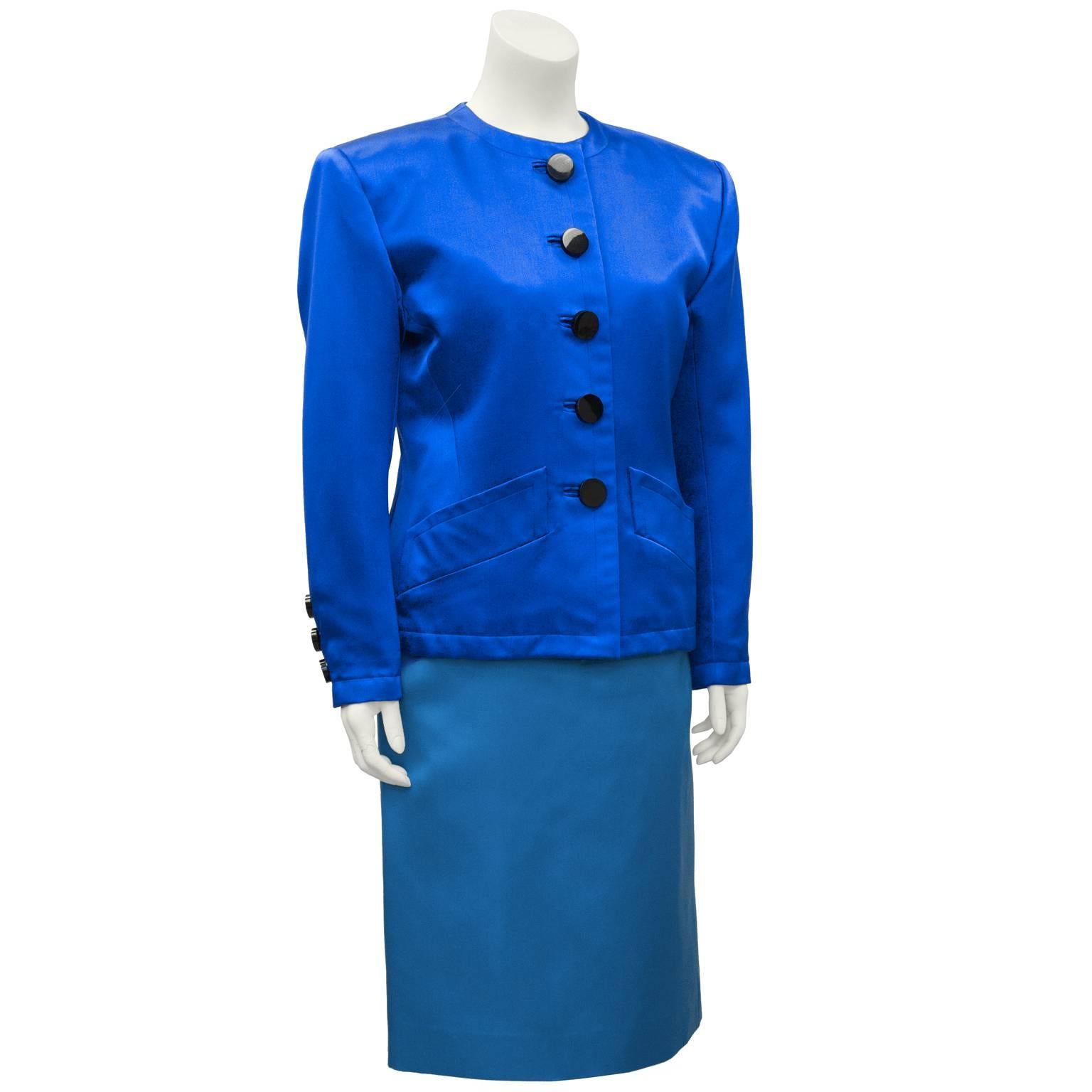 Unusual Yves Saint Laurent/YSL shades of blue skirt suit from the 1980's. Structured royal blue cotton jacket with a round collar, diagonal top slit pockets and large black buttons up the front. The teal blue skirt has a banded waist, matching top