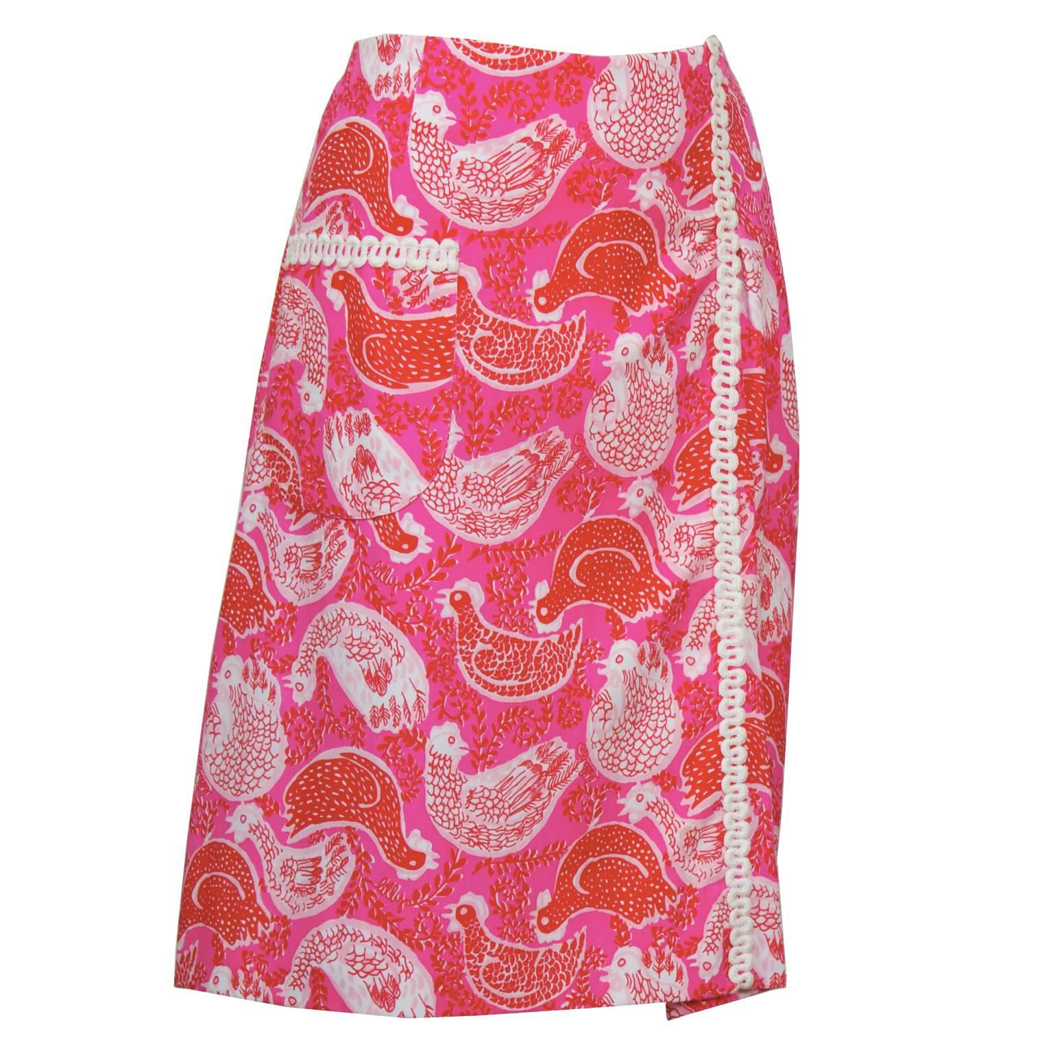 Pink and red rooster print Lilly Pulitzer wrap skirt from the 1960's. The skirt has one patch pocket on the front and white rickrack trim. In excellent, like-new condition, fits like a US 8-10.