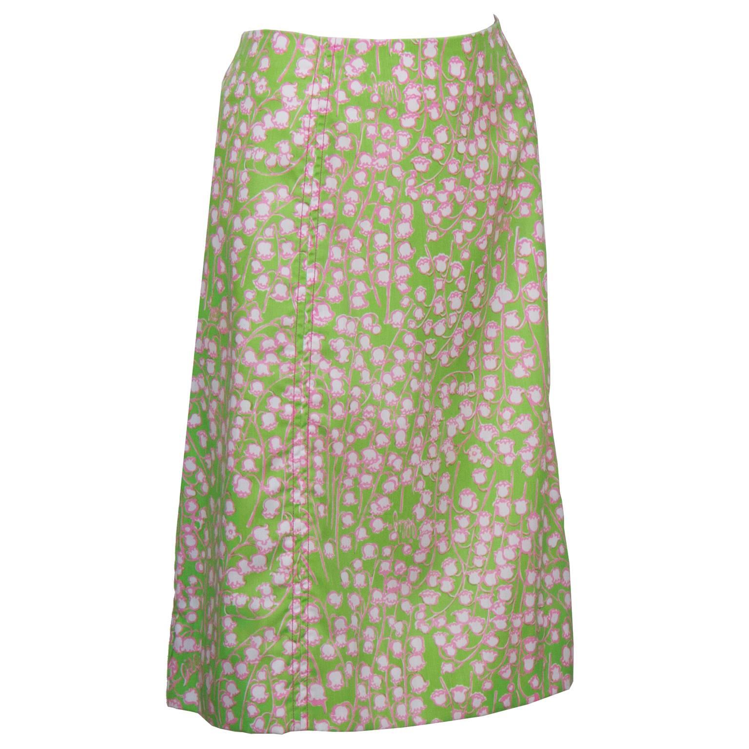 Classic style and pattern Lilly Pulitzer lime green skirt from the 1960's. The skirt has an all over print of white Lily of the Valley flowers outlined in pink. One side patch pocket, zipper up the back. In excellent condition. Fits like a US 8-10.