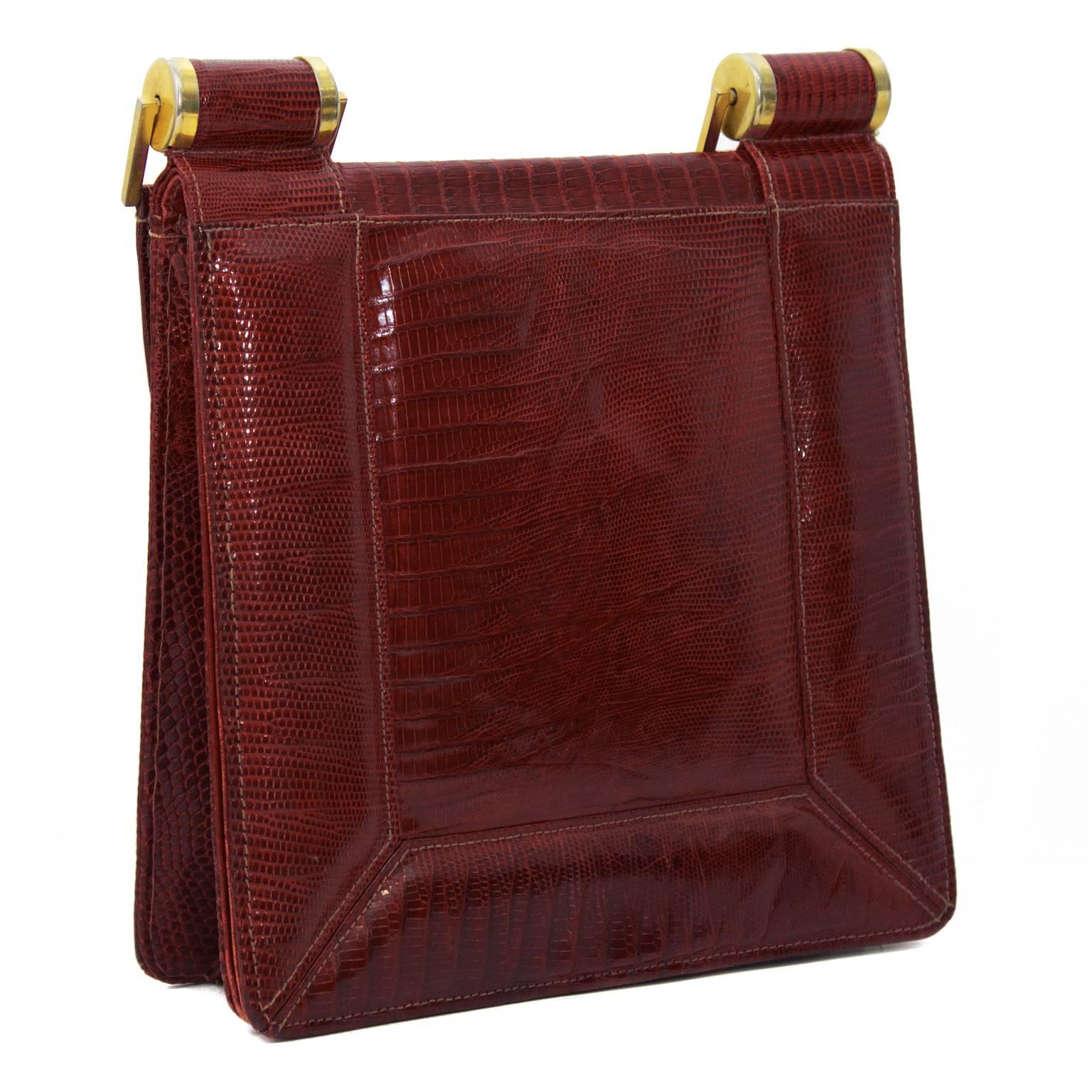 Modernist style burgundy lizard skin handbag from the 1940's. Square shape with a front flap closure. Handle is attached with large gold hardware links. Interior is lined in red leather with one zip pocket and two other compartments. Expandable