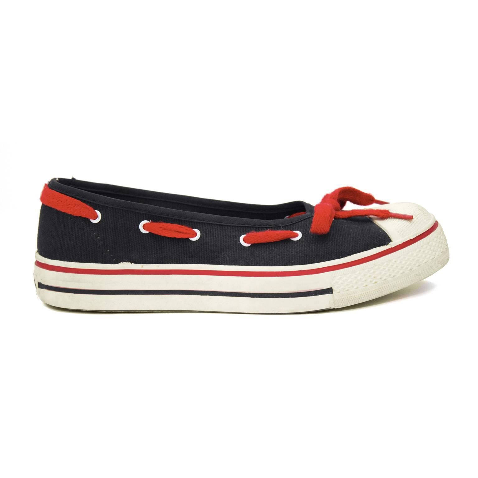 Very early pre OMO 1970's Norma Kamali black and white Converse inspired sneaker flats. From the same era as her iconic high heeled sneaker. White rubber soles and toe caps, black canvas body and red lacing detail around edge finishing in a bow. In