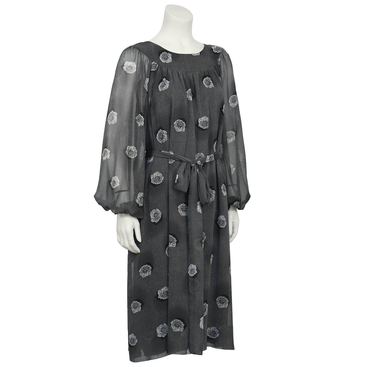 Loose fitting Hanae Mori gray printed chiffon dress from the 1970's. Yoke style neckline with see through chiffon Bishop style sleeves with elasticized cuffs. Dress features an allover gray speckled print with larger white and gray flowers. Dress is