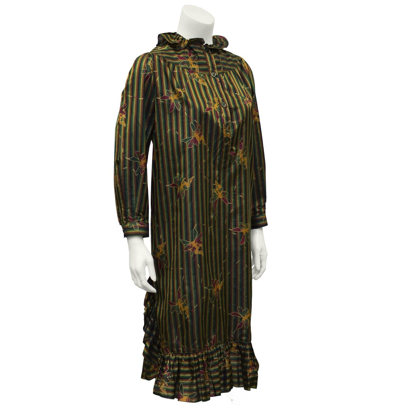 Navy, brown, gold and green striped day dress with a ruffle collar from the 1970's. Whimsical fairies featured all over the dress. Yoke and buttoned neckline, buttoned cuffs and ruffles along the hemline and side slits. In excellent condition, Very