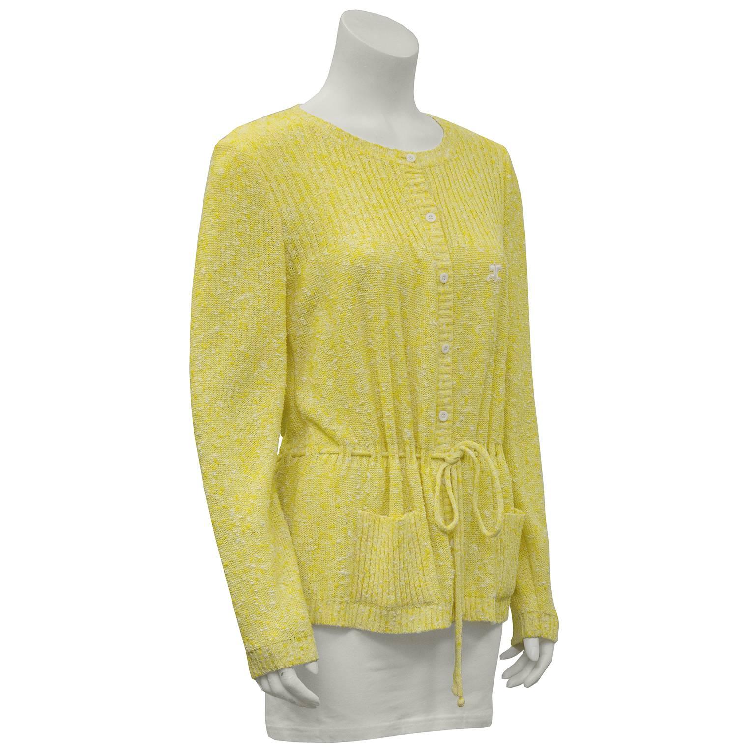 Knobbly yellow and white cotton knit cardigan by Courreges circa 1970. Button down the front with ribbed details. Drawstring belt through natural waistline. In excellent condition. Two patch pockets on the front. Fits like a US size 8.