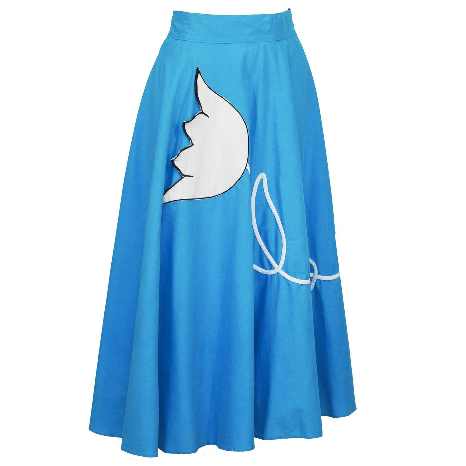 Turquoise cotton circle skirt from the 1960's. The white tulip applique stands out on the blue background and hides a pocket. A white stem twists along the front of the skirt in loops. Banded waist, side zipper. In excellent condition, fits like a