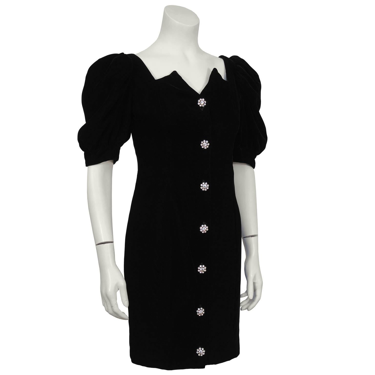 Black velvet cocktail mini dress by Lillie Rubin from the 1980's. The dress has an architectural sweetheart neckline and short puffed sleeves. Large rhinestone buttons fasten up the front with hidden small black snaps for added coverage. Matching