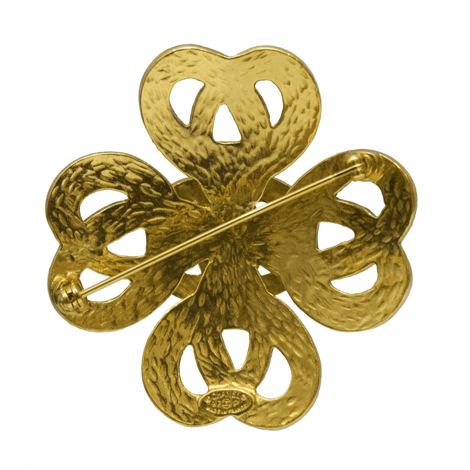 Chanel goldtone Celtic braided cross shaped pin from the 1997 Spring Collection. The pin has four points that are shaped like twisted hearts with a CC at the center. Signed plate on the underside. Closes with a safety catch. In excellent condition.