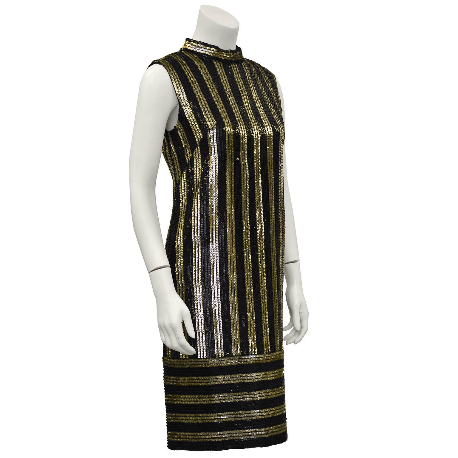 Anonymous gold and black sequin striped evening dress from the 1960's. The dress has a high collar, is sleeveless and has the all over detail of sequin stripes, vertical along the body and horizontal on the drop skirt. In excellent condition, zips