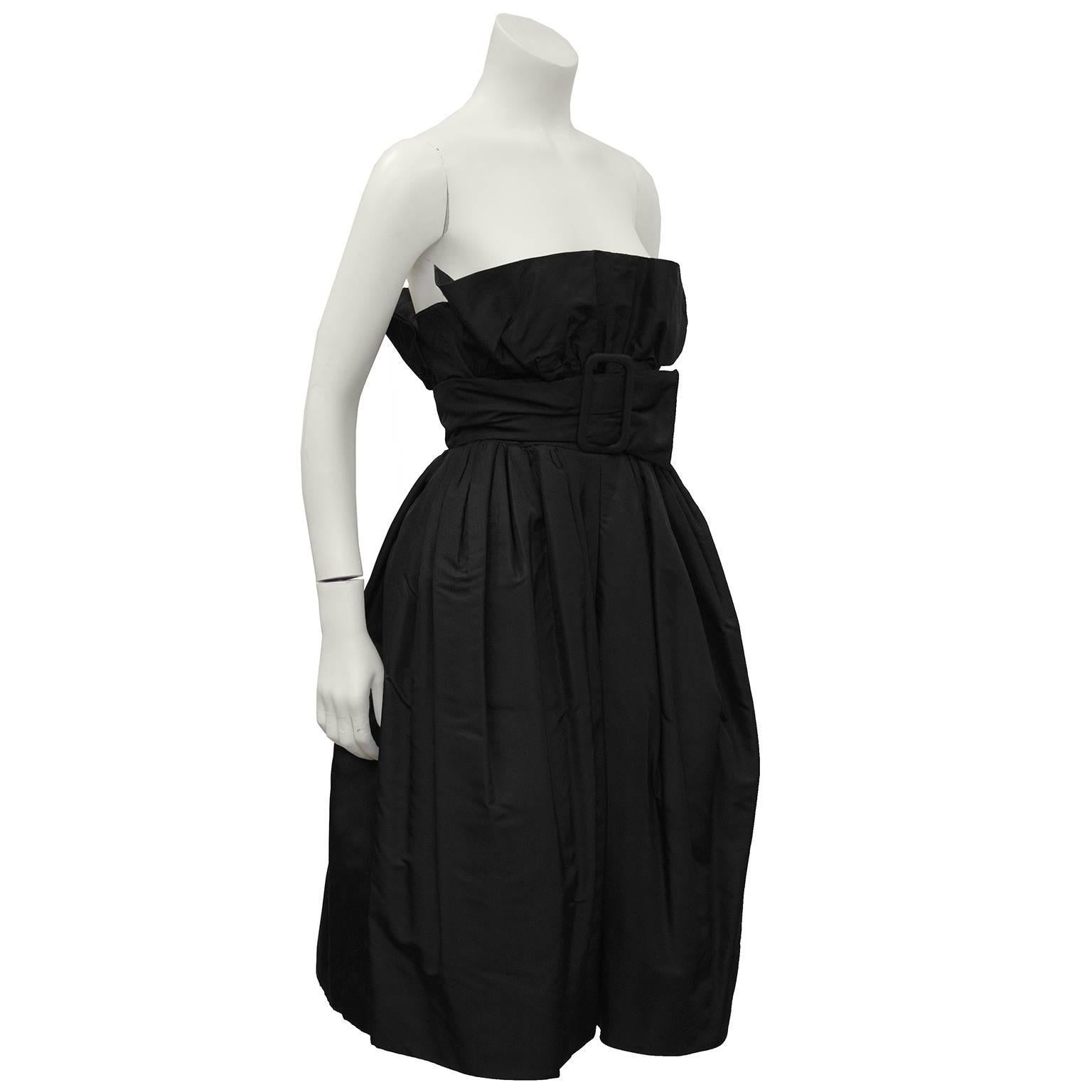 Elegant French couture, anonymous black silk taffeta belted pouf style cocktail dress from the 1960's. The dress has a 'crumb catcher' strapless neckline that is accentuated with an attached matching silk taffeta belt that fastens under the bust