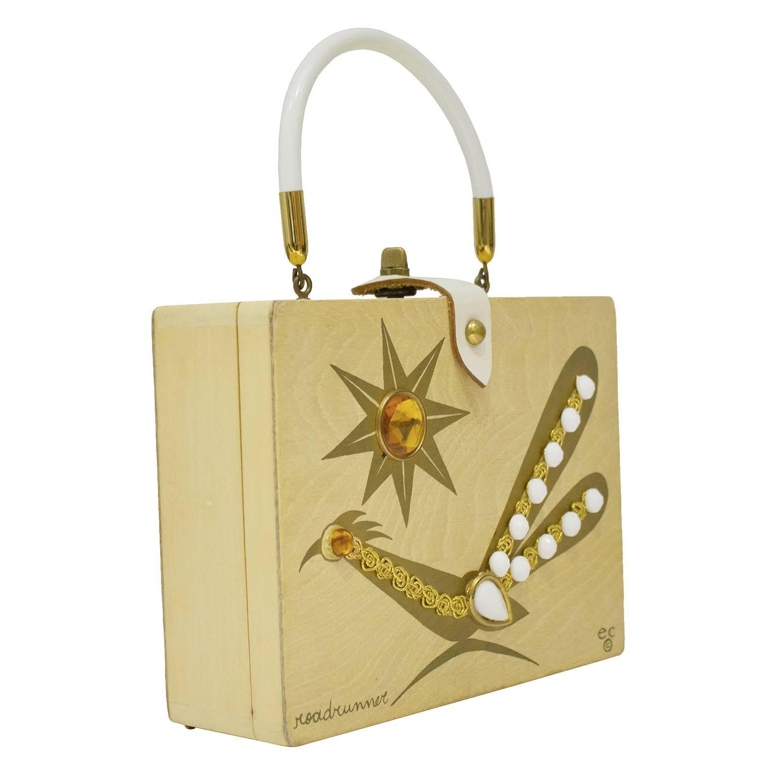 1960's Enid Collins/Collins of Texas light wooden square top handle bag. The bag features a Roadrunner and a star on the front adorned with gold hardware, white cabochons and amber rhinestones. Signed by Enid Collins on the front, the interior has a
