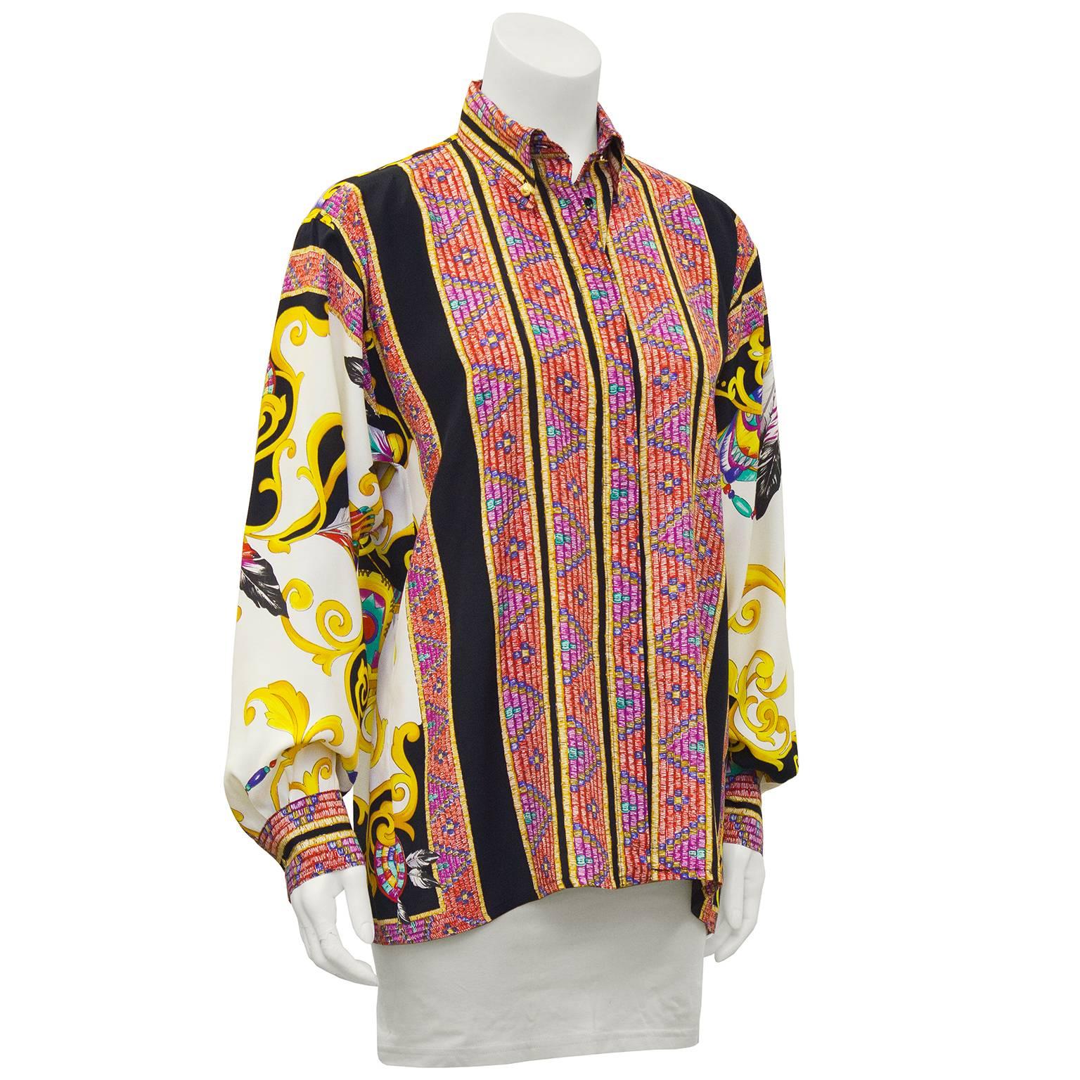 Eye dazzling circa 2000 Versace silk button front shirt. Gold Versace button details on collar points and cuffs. Placket covered buttons, square cut fit. Bold jewel tone vertical stripe patttern combined with swirly graphic design on the back and
