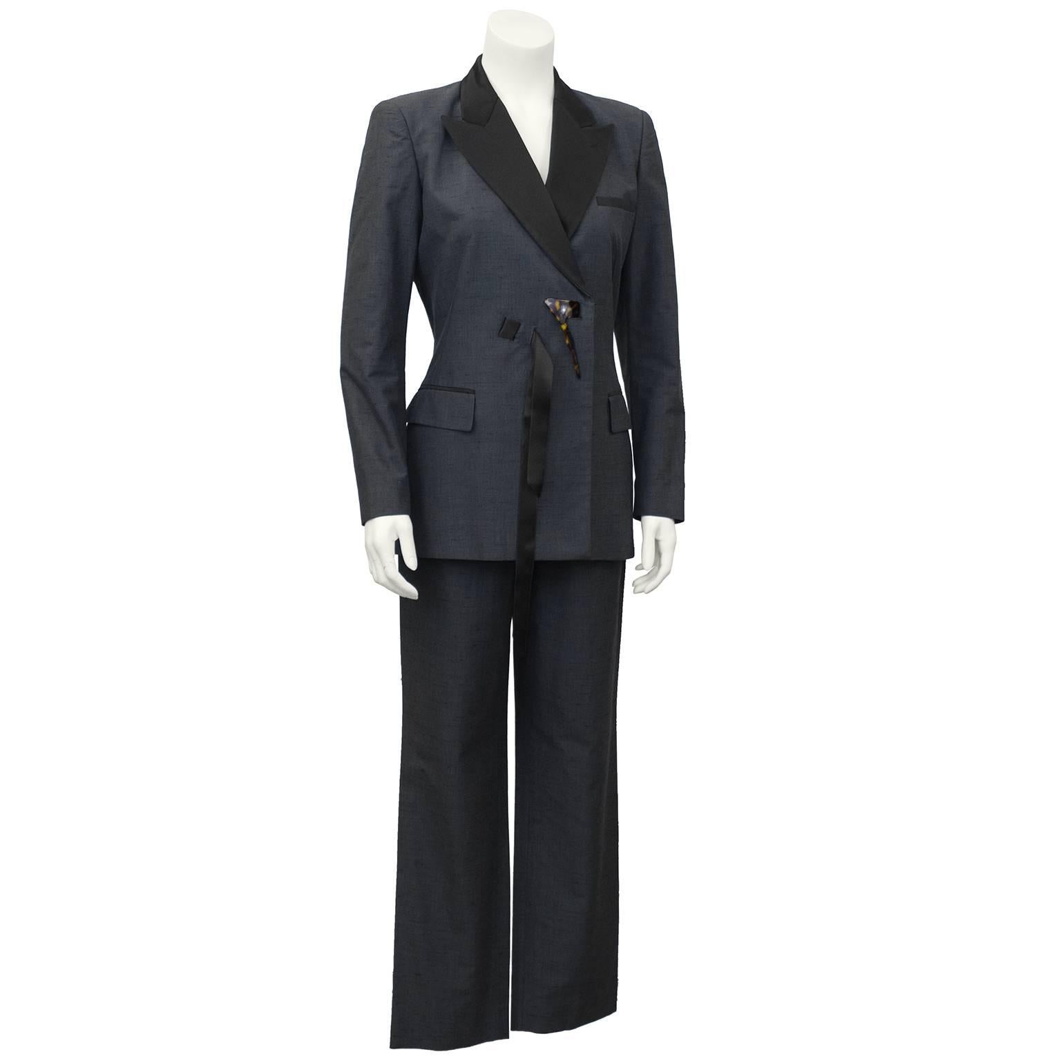1990's Jean Paul Gaultier grey and black tuxedo style pant suit with unusual Spanish mantilla style hair piece as jacket fastener. Alternate fastening with black satin ribbon. Black lapels and trim on breast pocket and and jacket flap pockets.