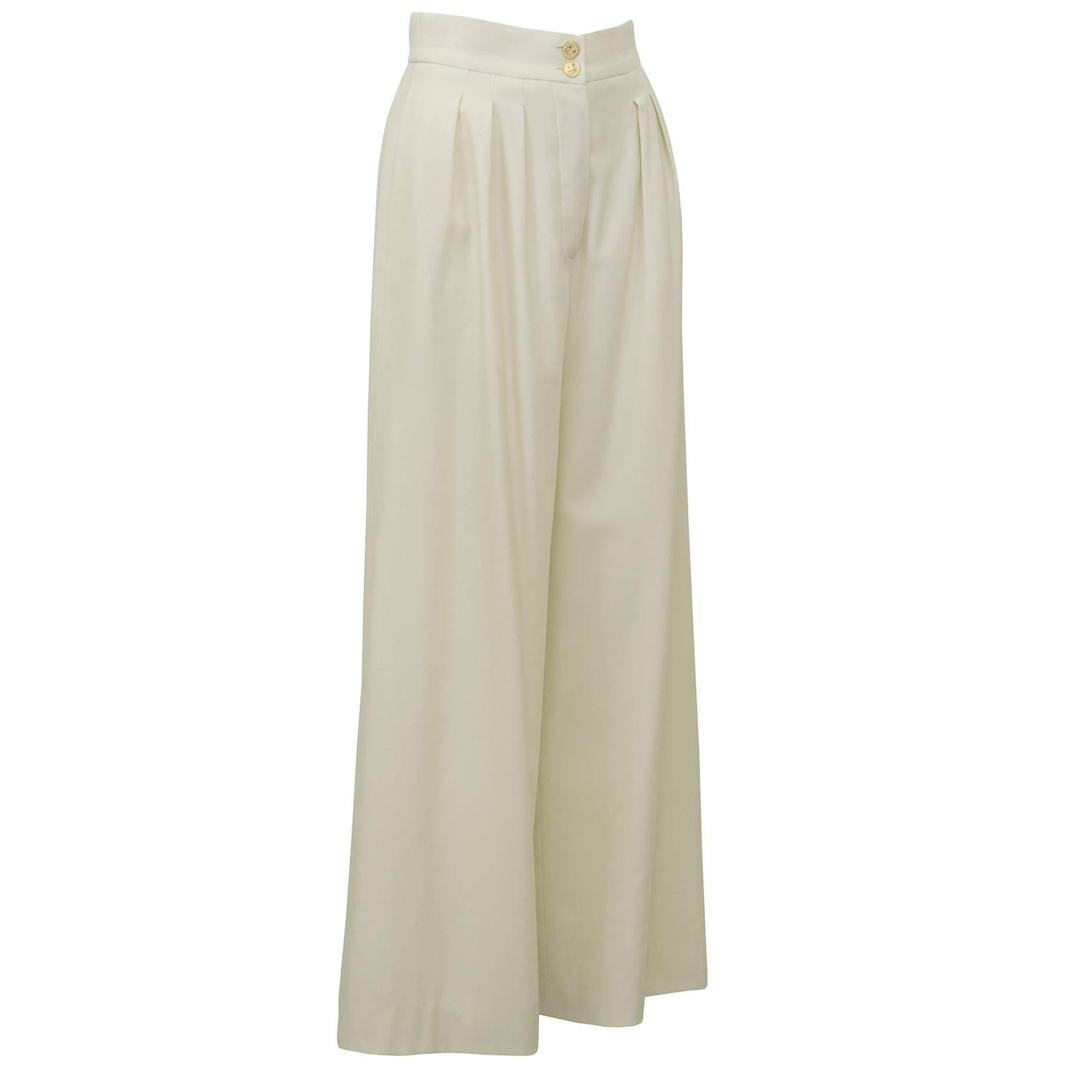 1990's high waisted, cream, wide leg Chanel trousers. Stunning cut and shape with the most classic gold four leaf clover Chanel buttons, in perfect condition. Mid weight wool for all seasons. Small hole from age and wear on right leg, otherwise