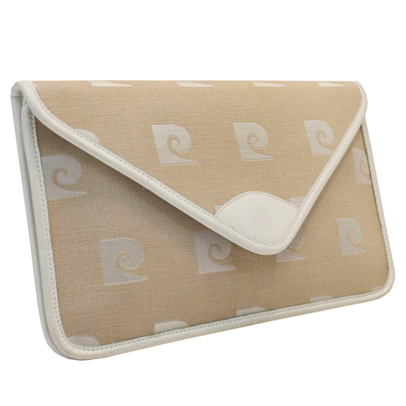 1960's Pierre Cardin logo clutch with detachable white leather handle. In excellent unused condition. Off white fabric body trimmed with white leather.

Length 11.75"  Width 7.5" Height 1.25" Strap 30"