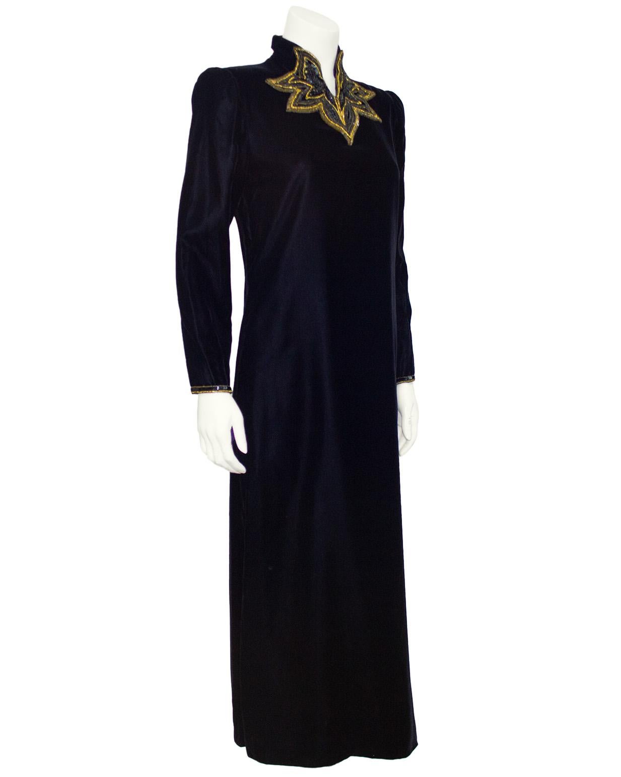 Dramatisch elegantes Kleid aus schwarzem Samt aus den 1980er Jahren von Jean-Louis Scherrer. Die schlanke und statuenhafte Silhouette lässt die filigranen schwarz-goldenen Perlen am hohen Ausschnitt in den Vordergrund treten. Lange Ärmel mit