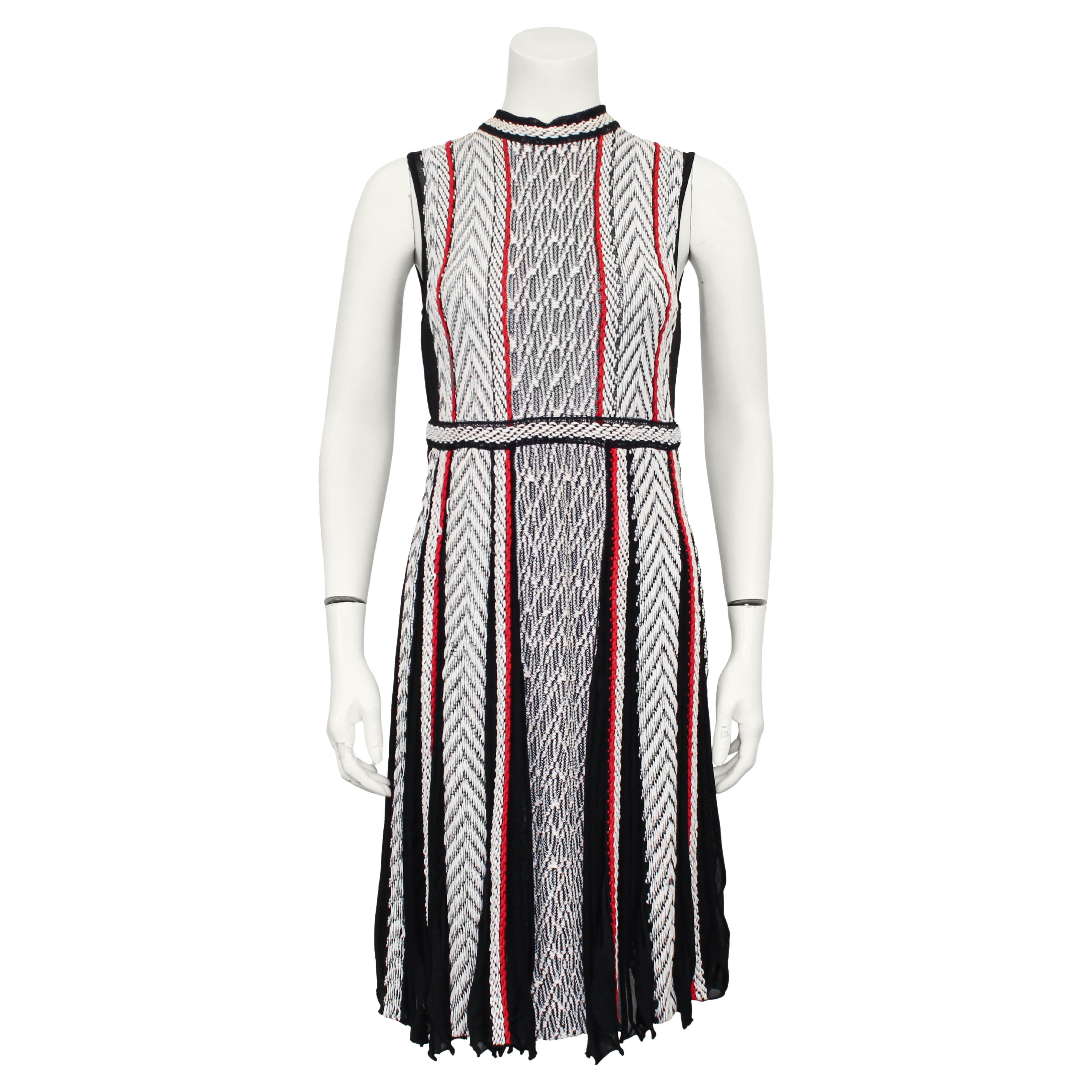 Set abito e giacca in maglia Oscar De La Renta della collezione primavera 2017. L'abito senza maniche al ginocchio è caratterizzato da spesse strisce verticali di diversi motivi a maglia intrecciata meticolosamente realizzati in nero, bianco e rosso