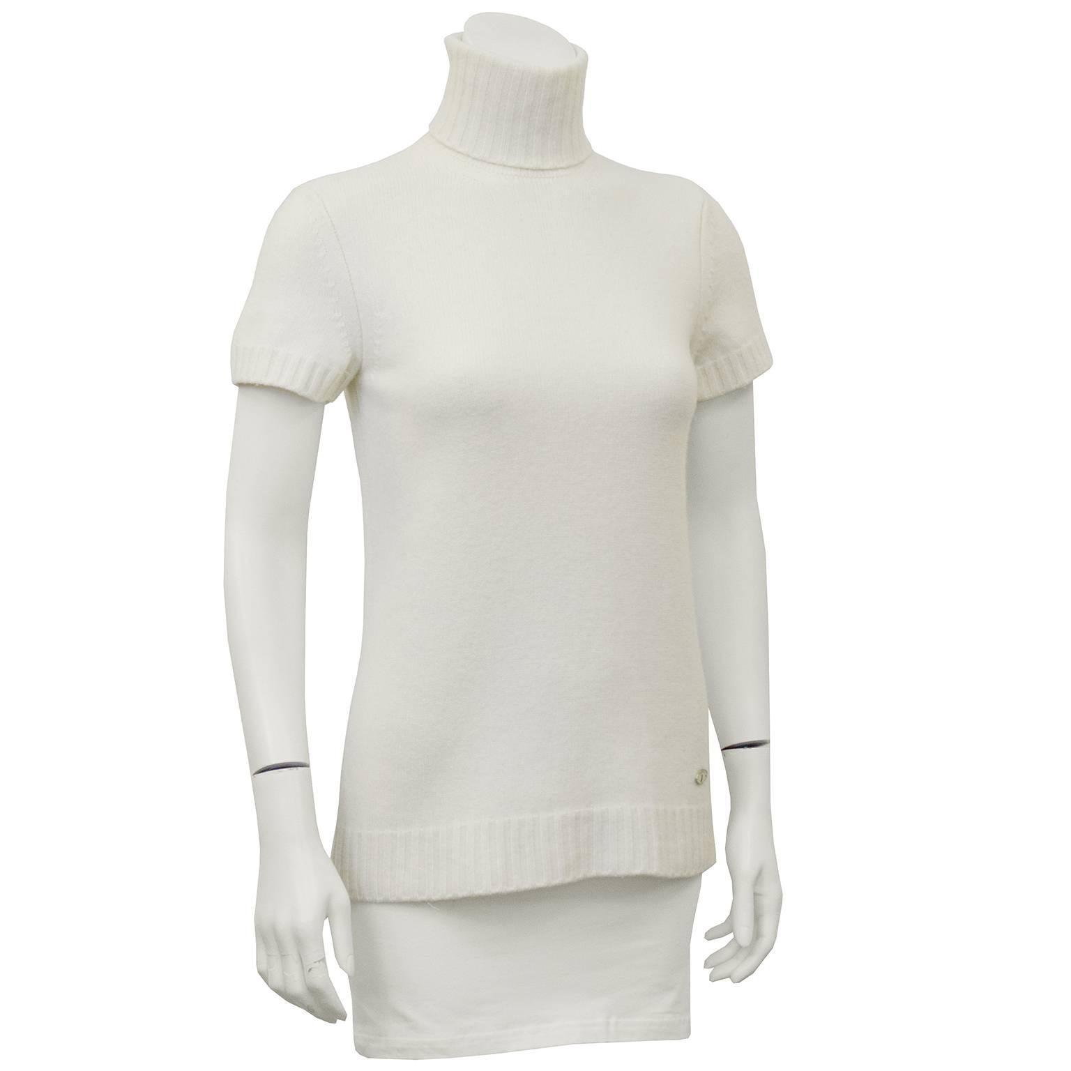 Early 2000's Chanel cream knit short sleeve turtleneck. Turtleneck folds over for a cozy look and has a short zip closure at back. Ribbed trim at neck, sleeves and hem. All labels have been removed, but small Chanel key lock logo on the left bottom
