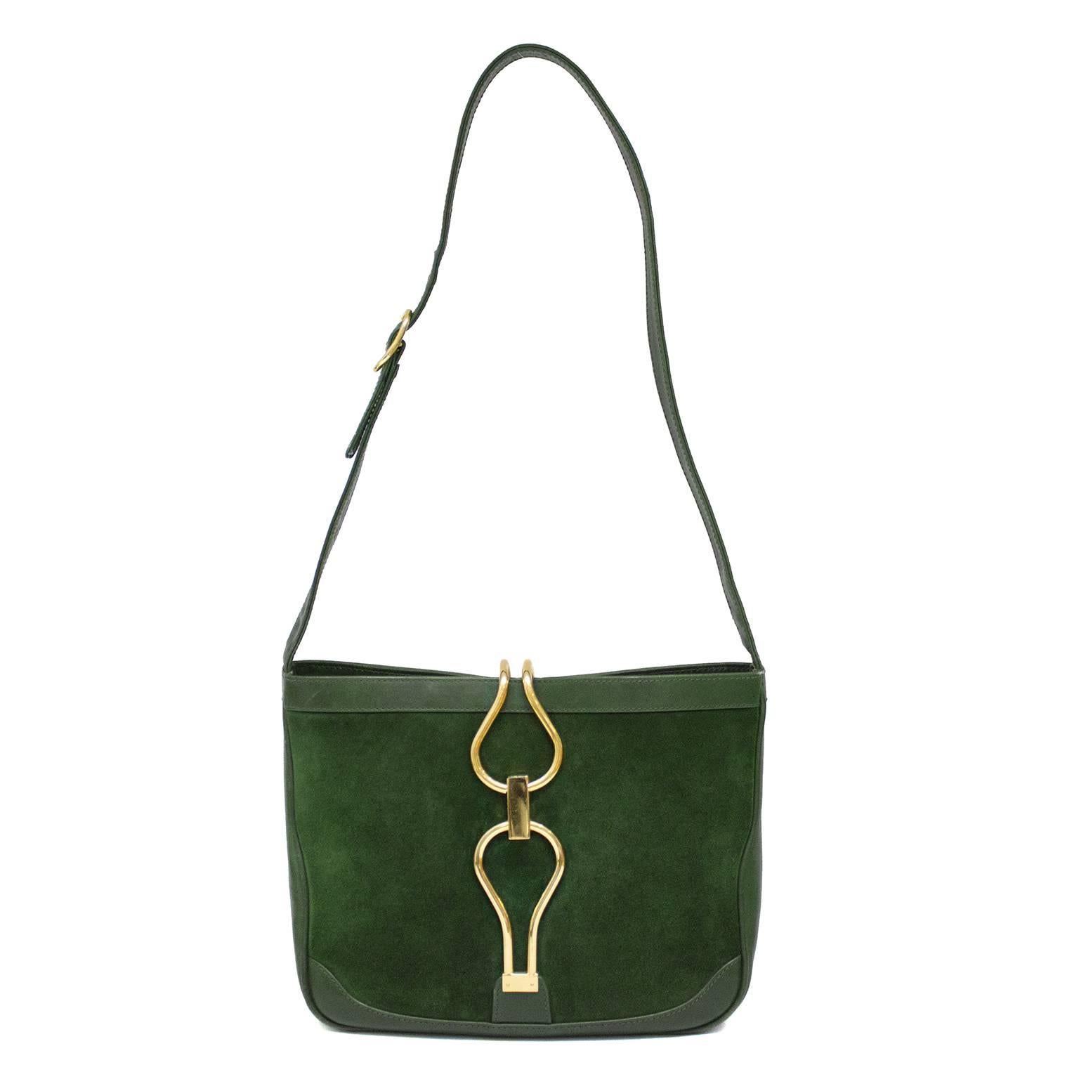 Uber chic 1970s Jackie O style Gucci shoulder bag. Hunter green suede with matching green leather trim. Gold hardware has very slight surface scratches. Cream leather interior, with one interior pocket with white zipper. Adjustable shoulder strap.