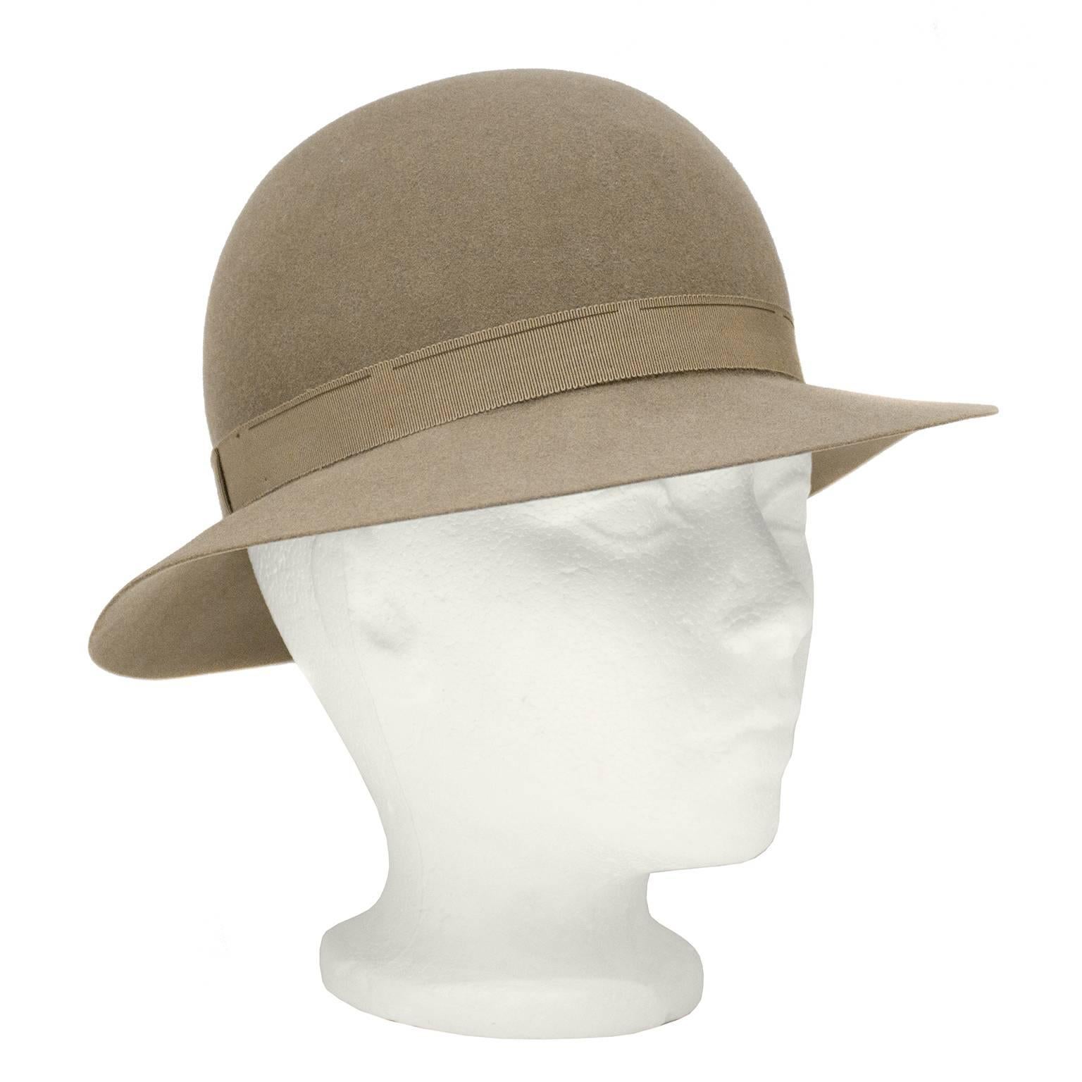 Darling 1970's Yves Saint Laurent taupe felt bowler hat. Matching taupe grosgrain ribbon trim on exterior and interior. Exterior ribbon features a flat bow. Excellent vintage condition. 

Diameter 22.5"