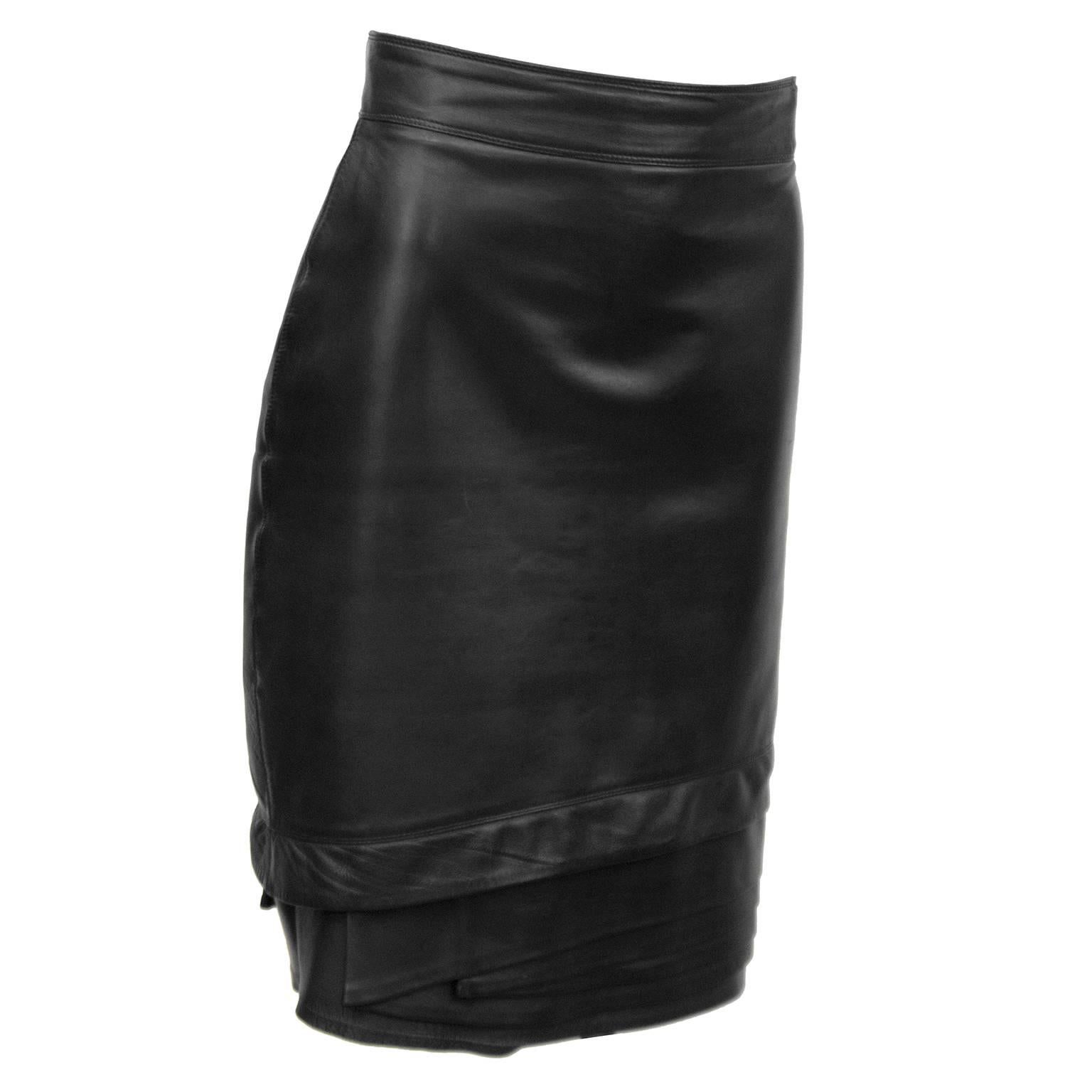 Black leather Gianni Versace skirt from the 1980s. The skirt has a banded waist and a beautiful tiered detail on the hem. Back zip, fully lined. In excellent condition. 

Waist 28" Hips 34.5" Length 23"