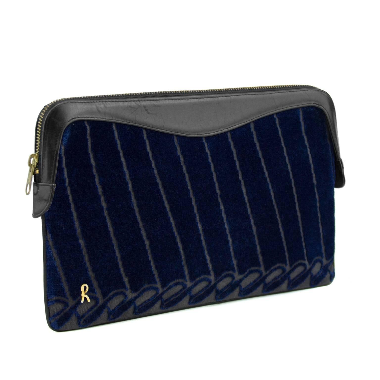 Beautiful 1970s Roberta Di Camerino navy velvet clutch. Trimmed in black leather with a zip top opening and signature goldtone R on the bottom corner. The leather interior is in perfect condition with one zip pocket and one smaller open pocket.