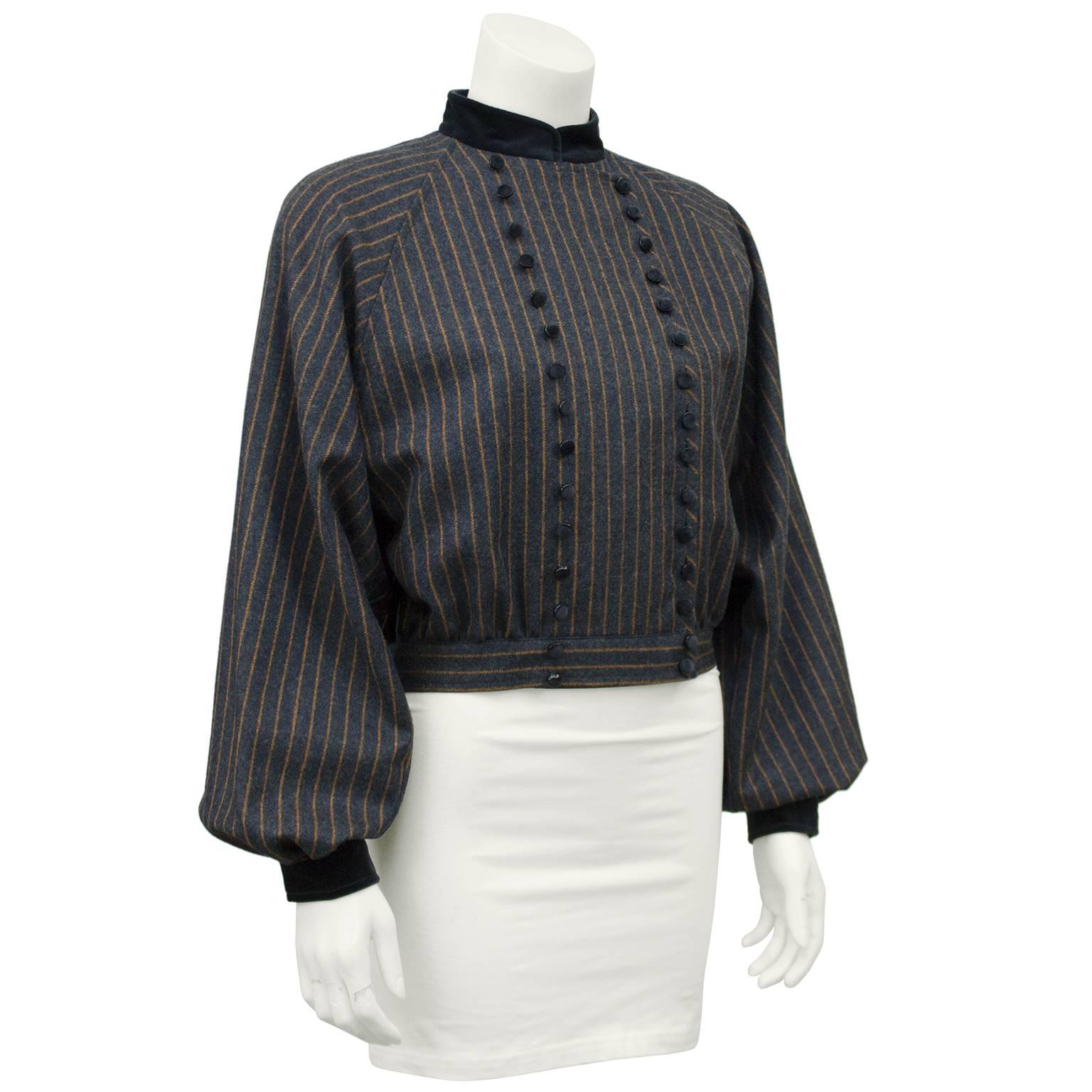 Valentino 1980s cropped wool military style jacket with velvet trim. The jacket has batwing style sleeves and is very full through the body with a fitted waistband. The wool fabric has an orange pinstripe throughout and fastens up the front with 15
