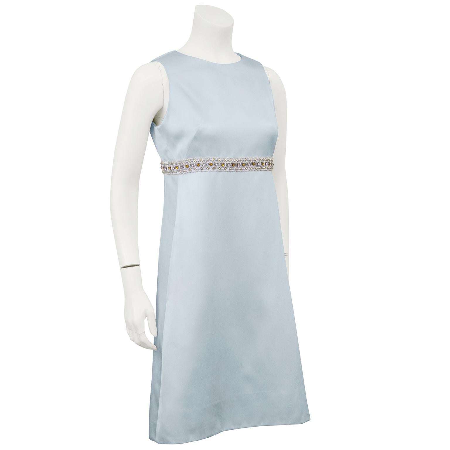 Beautiful ice blue A line cocktail dress from the 1960s by the Hong Kong based British clothing line Dynasty. Known for their beading techniques, this Dynasty piece has a lovely silver thread and rhinestone belt that is attached and accents the