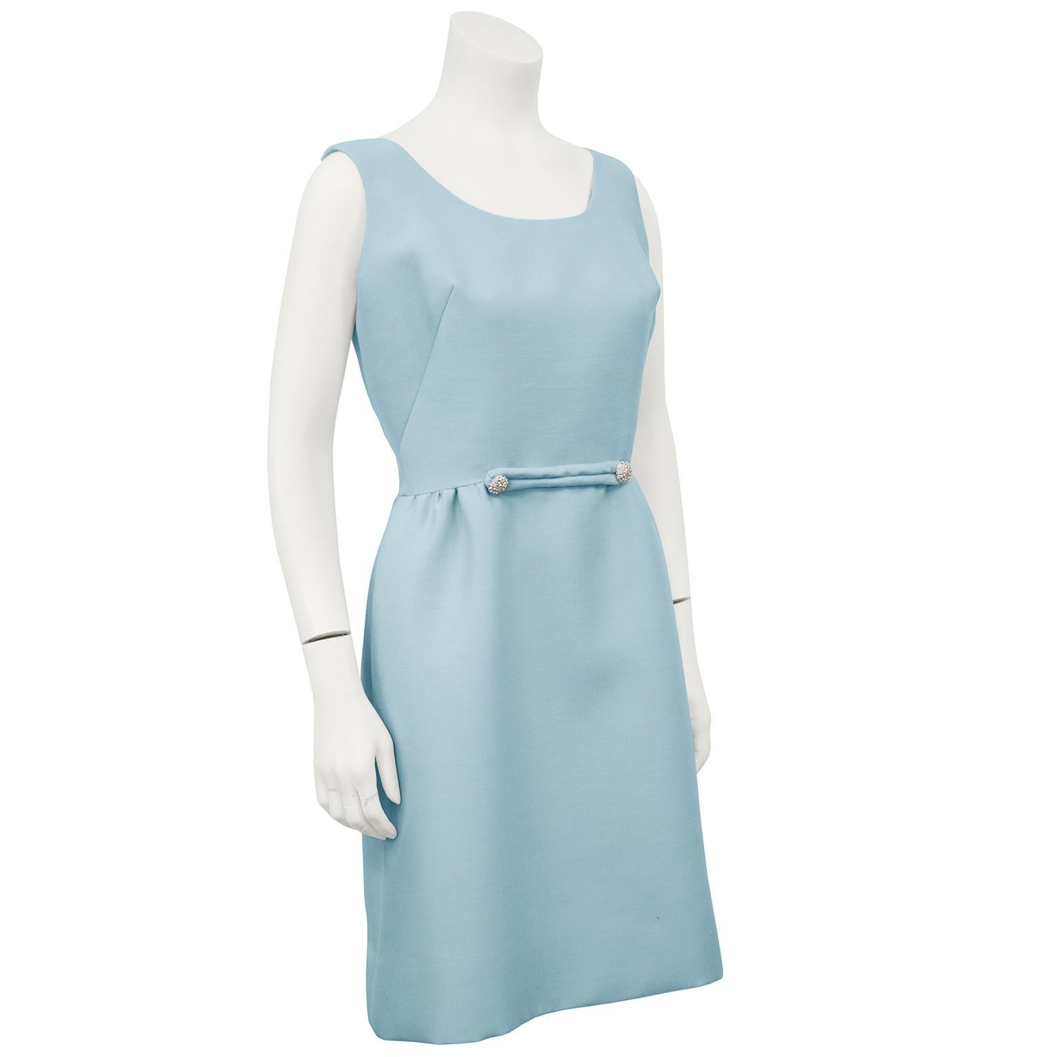 Robin's egg blue cocktail dress from the 1960s. Classic shape is finished with a simple belt accent at the natural waist with two rhinestone buttons. Darts at the bust, zipper up the back. Fully lined, fits like a US 4-6. In excellent condition. 
