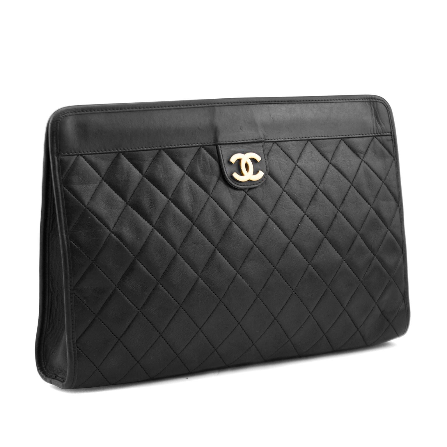 Black quilted leather clutch from Chanel featuring a gold-tone signature logo on leather tab at the front, a concealed magnetic fastening and signature maroon red lining. The sophisticated quality and timeless style of this clutch lend a look of
