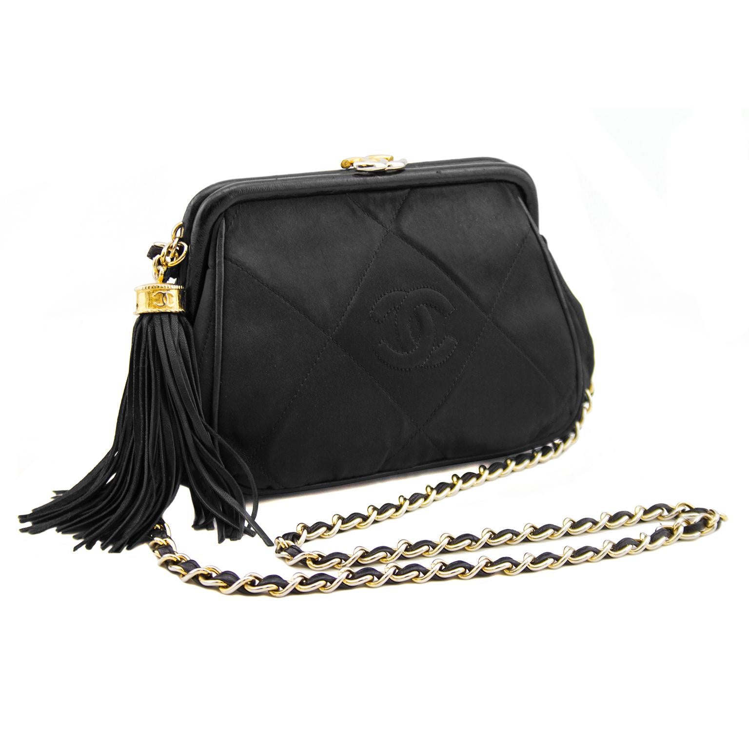This sweet little bag is crafted of beautiful black diamond quilted silk with a CC logo on the front and leather tassel embellishment. Featuring a braided shoulder chain and frame made out of leather. This opens with a gold CC snap closure to a red
