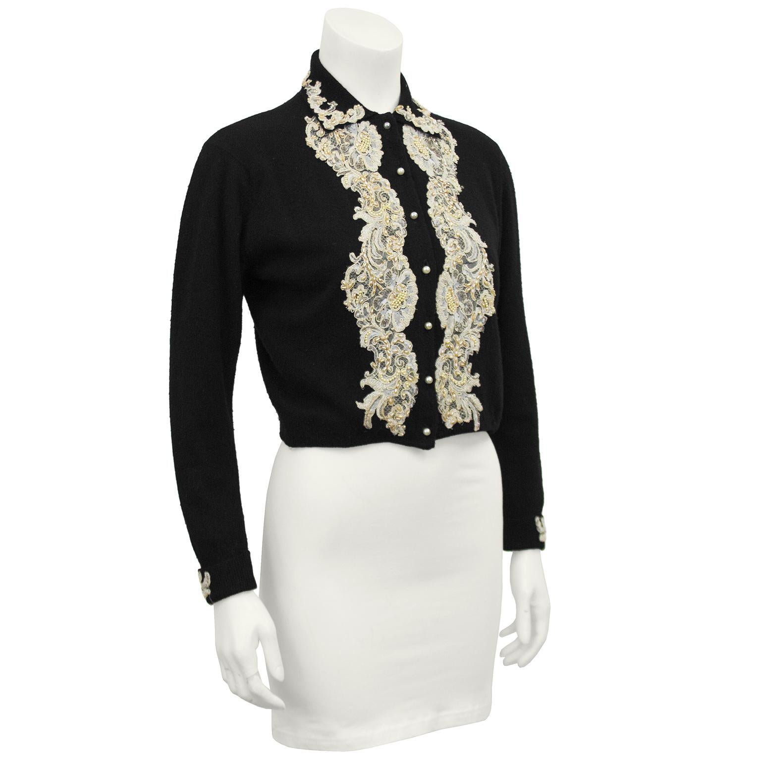Gorgeous black cashmere cardigan sweater from the 1950s. Beautifully made with cream lace and pearl applique along the collar, down the front, on the cuffs and in floral patches over the back. Pearl buttons down the front with hidden snaps for added