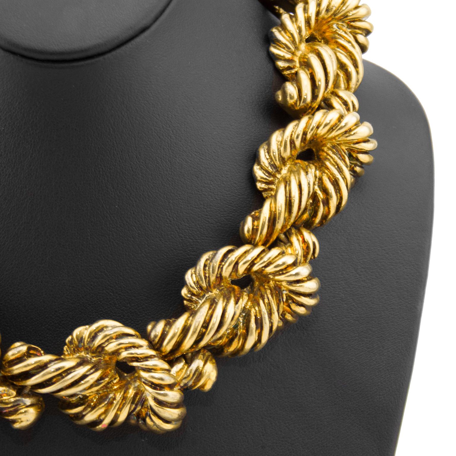 Chunky statement necklace by Christian LaCroix from the 1980s. Worn choker style, the goldtone links resemble large knots and are connected with screws that allow them to move and bend. The knots are flat on the underside and the necklace fastens at