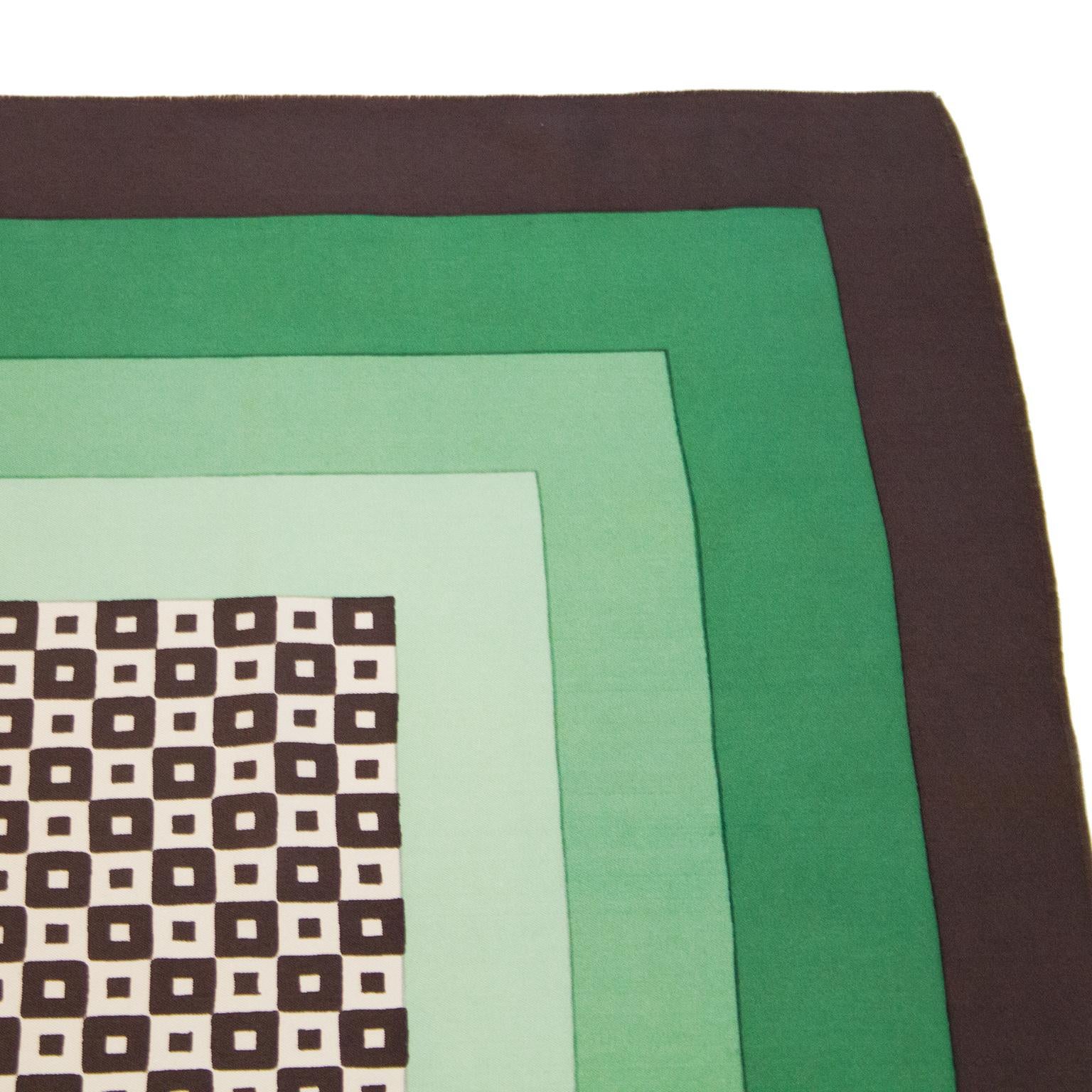 YSL modernist mid century silk scarf from the 1970s. The center is a geometric pattern of brown and beige squares surrounded with 3 borders of gradient green shades and finished with a dark brown border and an unfinished edge. Signed on the bottom