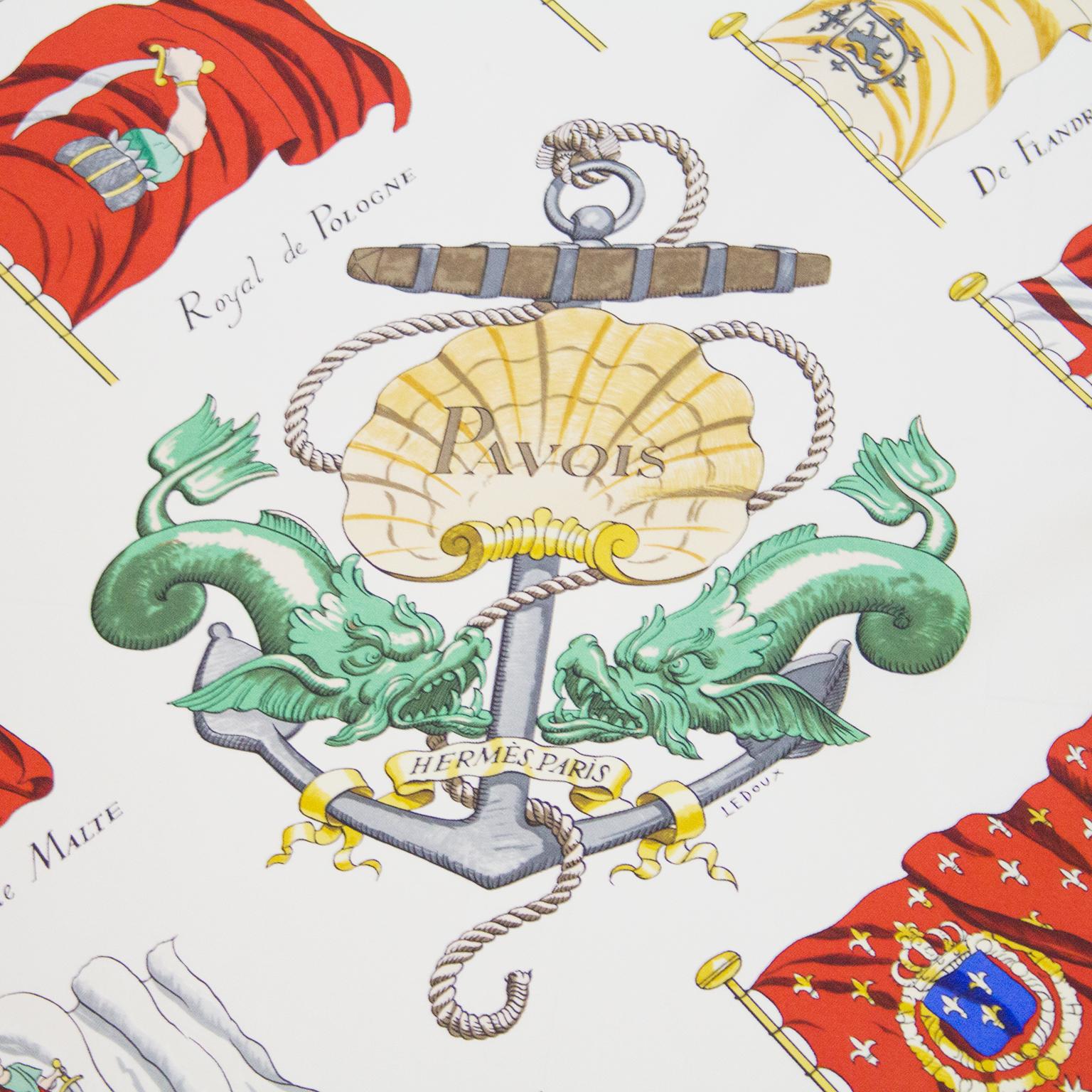 Designed by Philippe LeDoux in 1964, the scarf has a white background with a multi national nautical flag pattern surrounding an anchor with a shell, dragon fish and rope. In excellent clean crisp condition, 100% silk, 35” square. Signed throughout