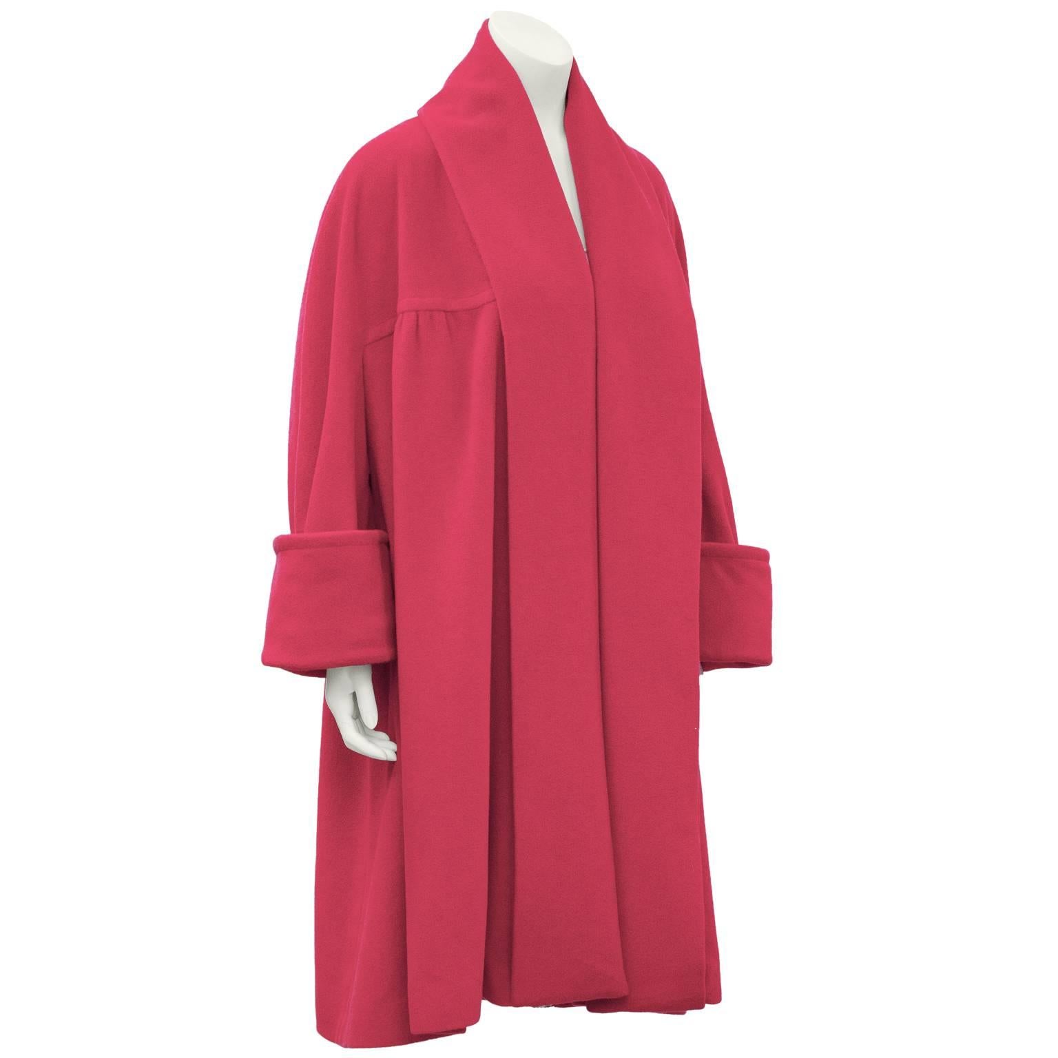 Chanel hot pink cashmere oversized robe style swing coat from Fall 1991. The coat has wide shawl style lapels, side slit pockets, and wide banded cuffs. It features gathering yoke seam that travels across the bustline and back. Finished with 3 gold