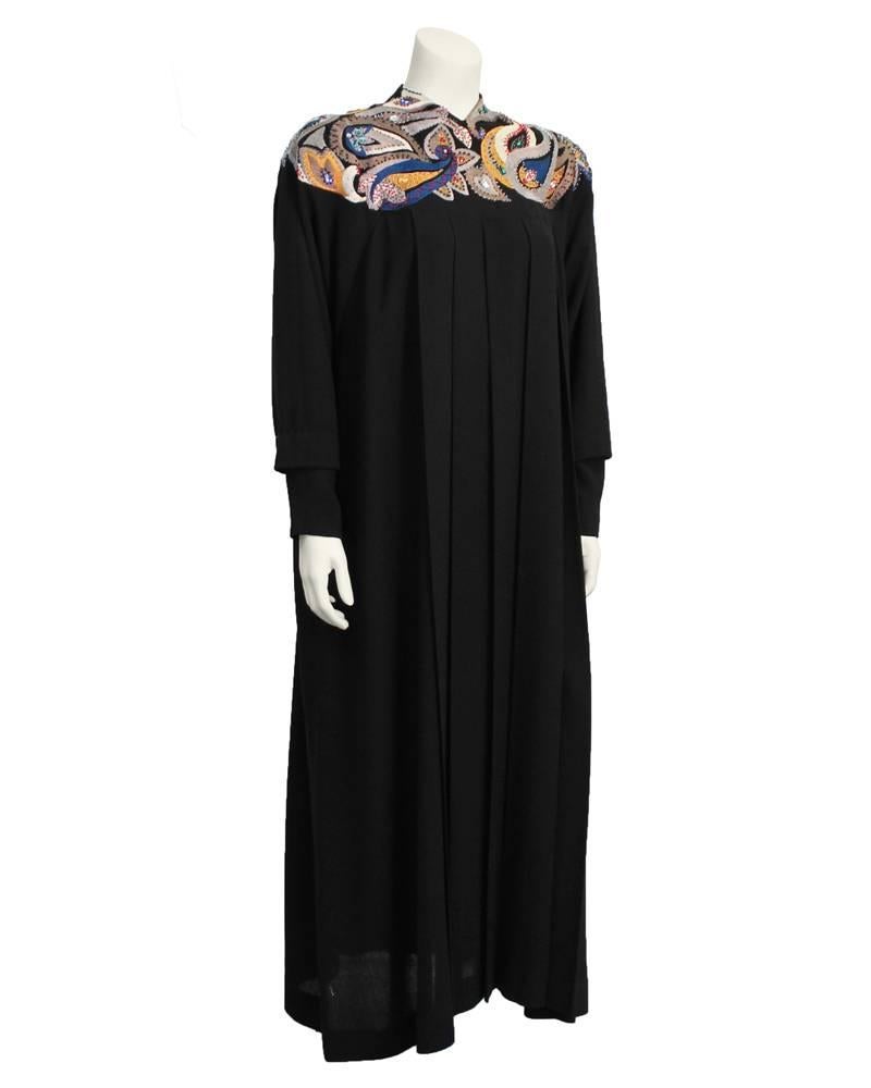 BEYOND amazing Emmanuelle Khanh black pleated wool long sleeve gown from the 1980's. Eye is drawn to the stunning hand sewn paisley pattern embroidery and beading. Embroidery and beading has muted tones of grey and beige, with pops of bright blue,