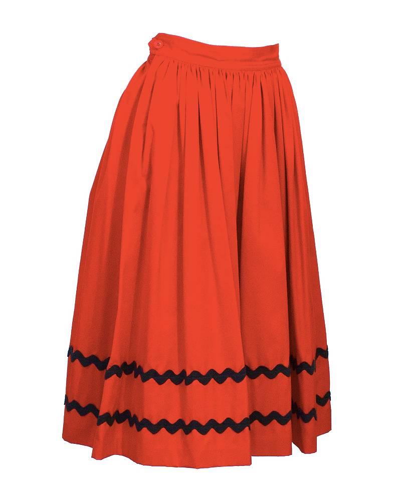 Very cute fire engine red Yves Saint Laurent dirndl skirt from the 1970's. Cinched at waist, with a full skirt, softly gathered. Black chevron rickrack detail at bottom. Excellent vintage condition.