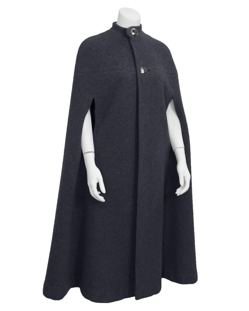 Fabulous 1970's grey wool cape from Pauline Trigere's more contemporary line of coats, “A Trigère Coat” for manufacturer Abe Schrader. Stunning with a raised collar and 2 large, interesting buttons. Fully lined in grey silk. some demure stitch