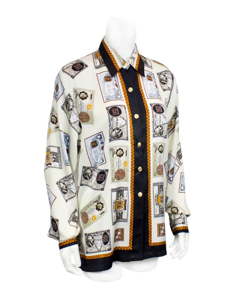 Fendi 1980's silk tunic style shirt with printed currency motif on a cream background. Ornate gold Fendi logo buttons add to the over the top look of this great vintage shirt. Black, cream and copper are the featured colors. In excellent vintage