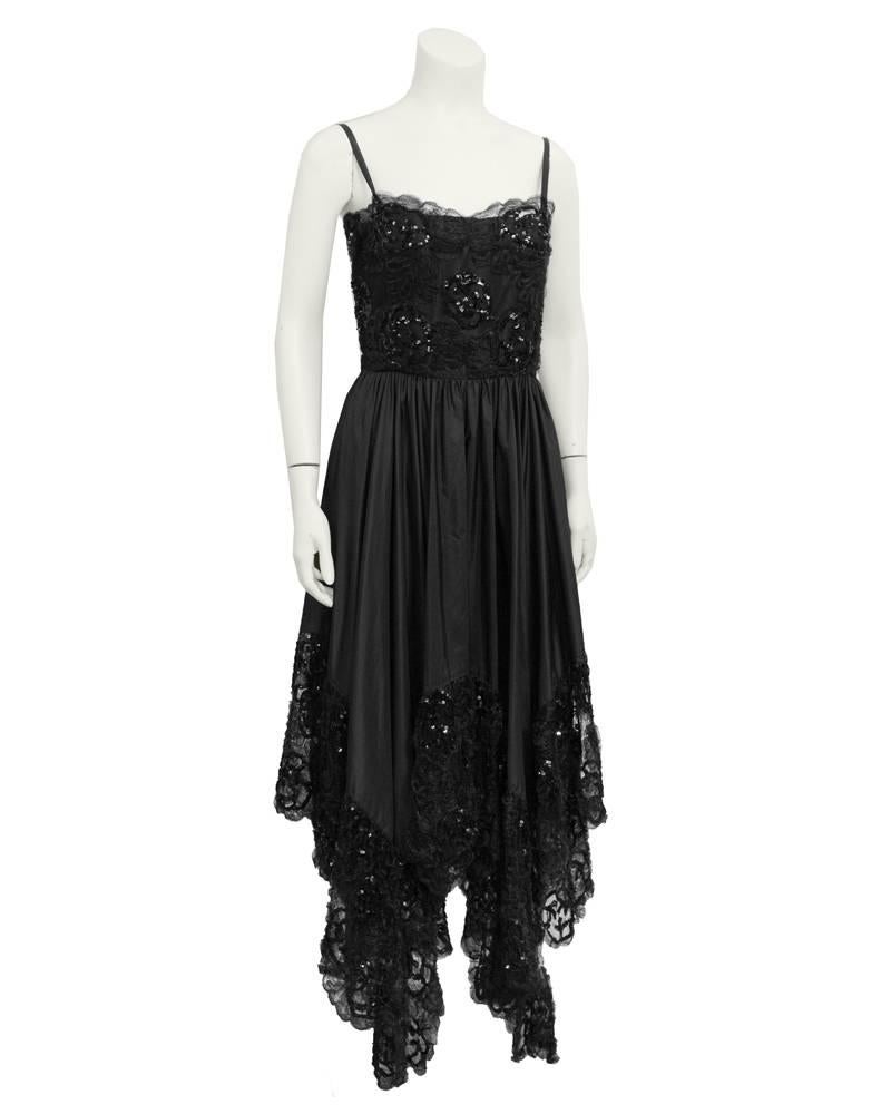 Einzigartiges Cocktail-/Abendkleid von YSL mit Taschentuch-Saum aus den frühen 1980er Jahren. Der Spitzenbesatz am Saum und am gesamten Mieder hat einen Hauch von Glitzer mit tiefschwarzen Perlen. Der Seidenrock ist weit ausgestellt, die Taille