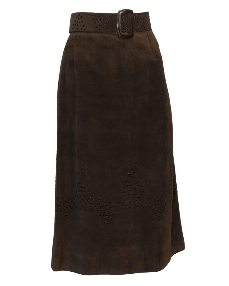 1970's deep brown suede midi A-line skirt by Tiktiner. Navy blue and brown grommets in a abstract chevron pattern around bottom half of the skirt. Matching belt with a brown metal buckle and the same grommets throughout. Minor chipping on belt