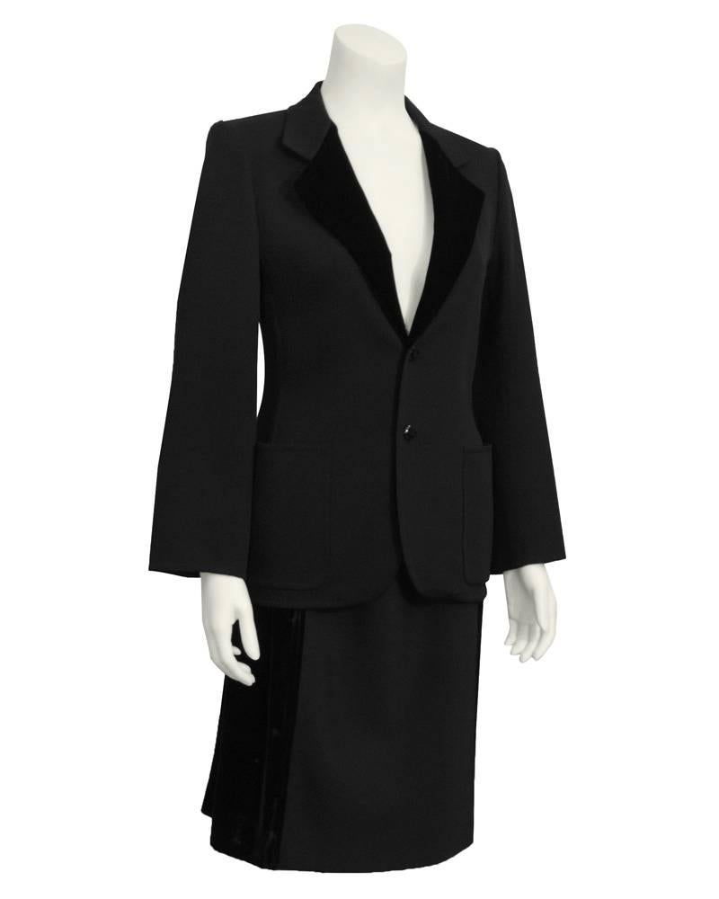 Smart 1970's black Mila Schon skirt suit. Wool with jet black velvet lapels and side panels on the skirt. Two front buttons on the single breasted jacket. Elastic waist skirt. Excellent vintage condition. The perfect dinner suit or dress jacket over