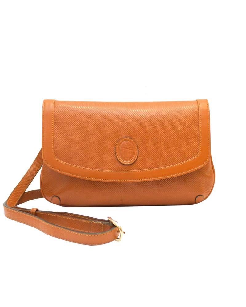 From the coveted handbag line by Mark Cross, this honey brown cross hatched leather clutch is great for everyday as it allows you to be hands free and fashionable! Dating from the late 1980's this bag has an adjustable long strap that can be removed