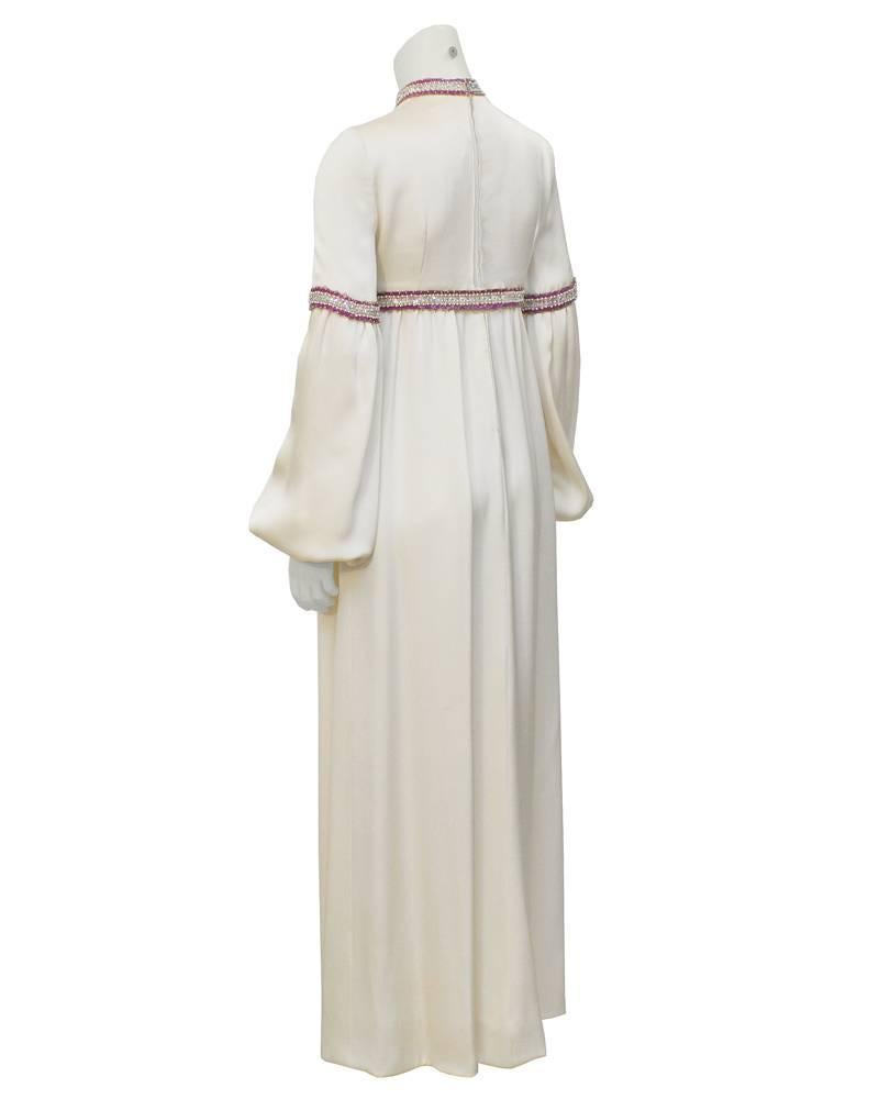 Amazing 1970's Guy Laroche couture cream silk gown. High neckline, billowing sleeves and empire waist. Simple almost religious lines, this elegant piece appears highly influence by Balenciaga.  Beautiful hot pink, gold, white and silver sequins and