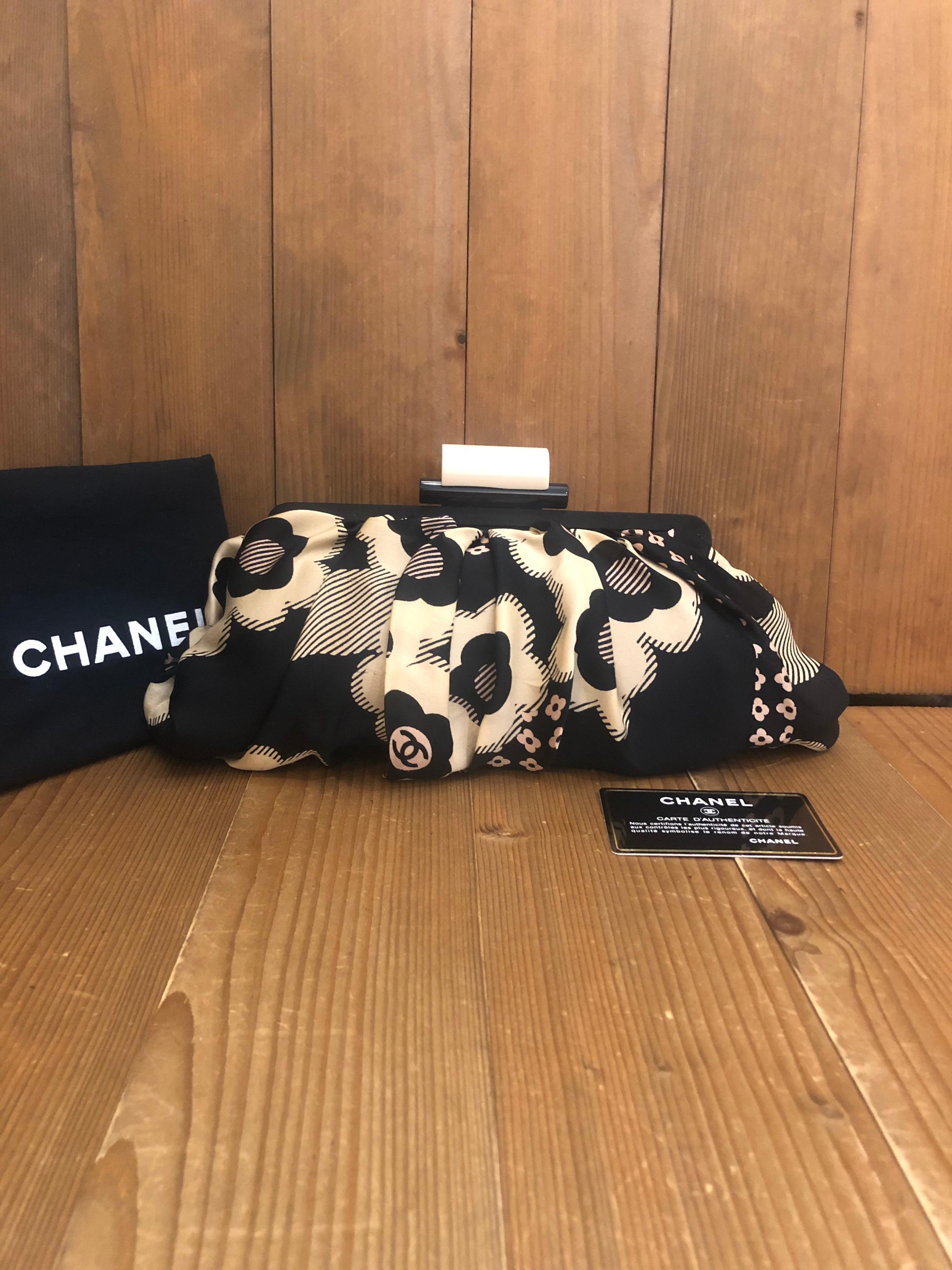 2005 Chanel clutch in black and white camillia printed silk with Chanel jacquard interior. Resin spring clasp closure. Measurement 21 x 12 x 8 cm (8 x 4.5 x 3 inches). Made in Italy. Comes with authentication card and dust bag.

Condition: Some
