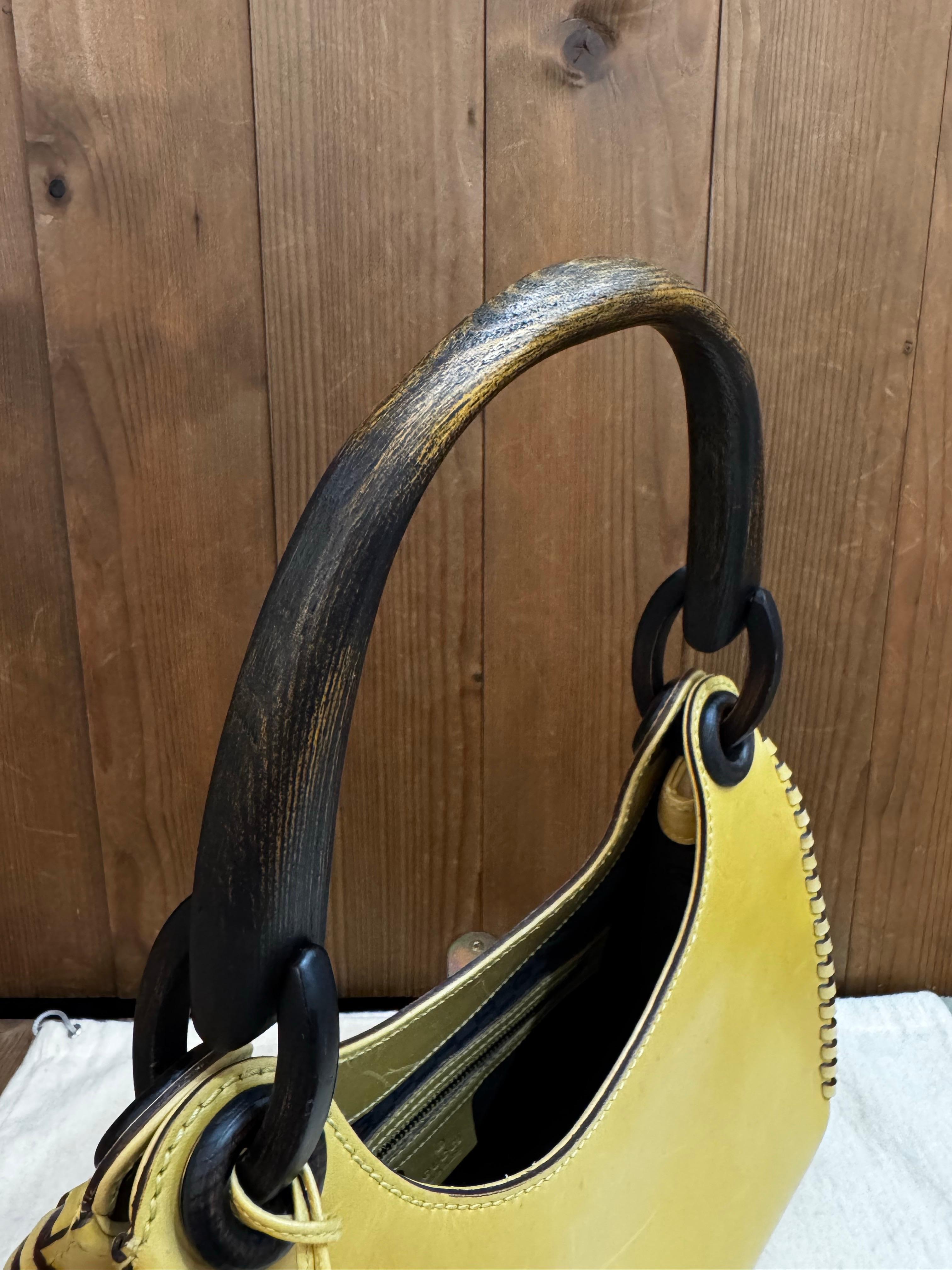 This GUCCI handbag is crafted of smooth calfskin leather in yellow featuring a wooden handle. Wide top opens to a GG jacquard interior with a zippered pocket. Made in Italy. Measures approximately Top 9 Bottom 12 x 9 x 5 inches. Comes with