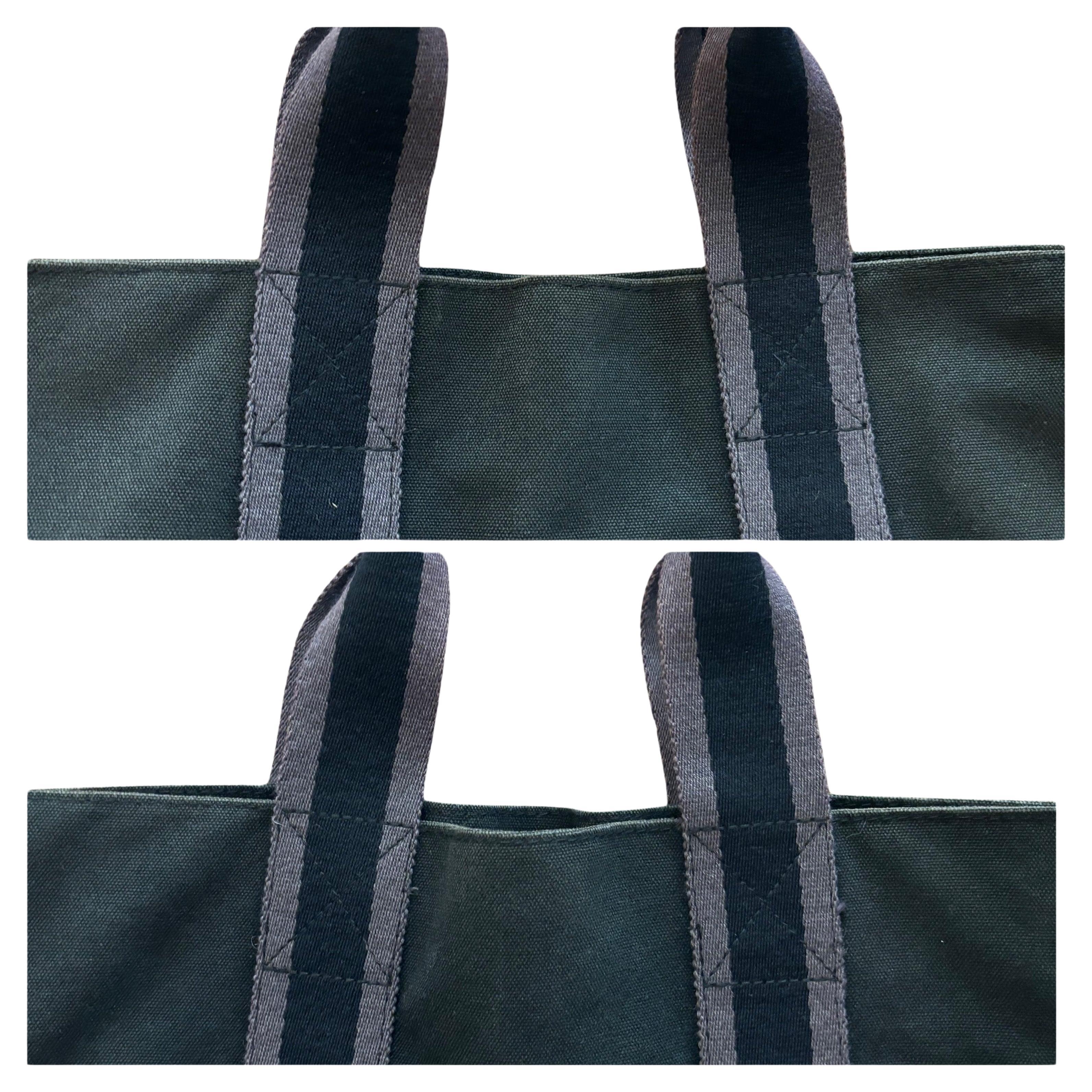 This vintage HERMES Tall Fourre Tout is crafted of cotton in black decorated with gray stripe featuring three exterior slip pockets. Wide top opens to an interior lined with the same cotton featuring a slip pocket. Measures approximately 14 (top) 12